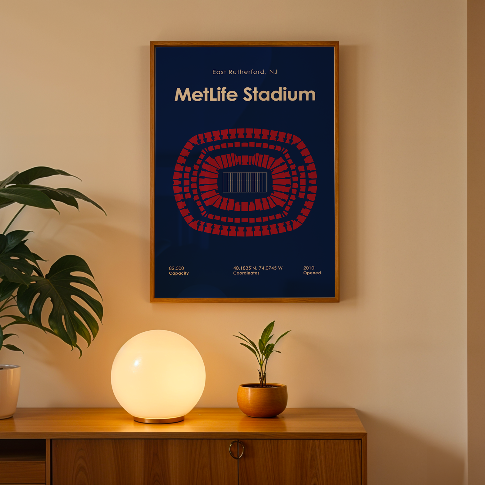 Framed poster of MetLife Stadium on a wall above a wooden cabinet with decorative items.