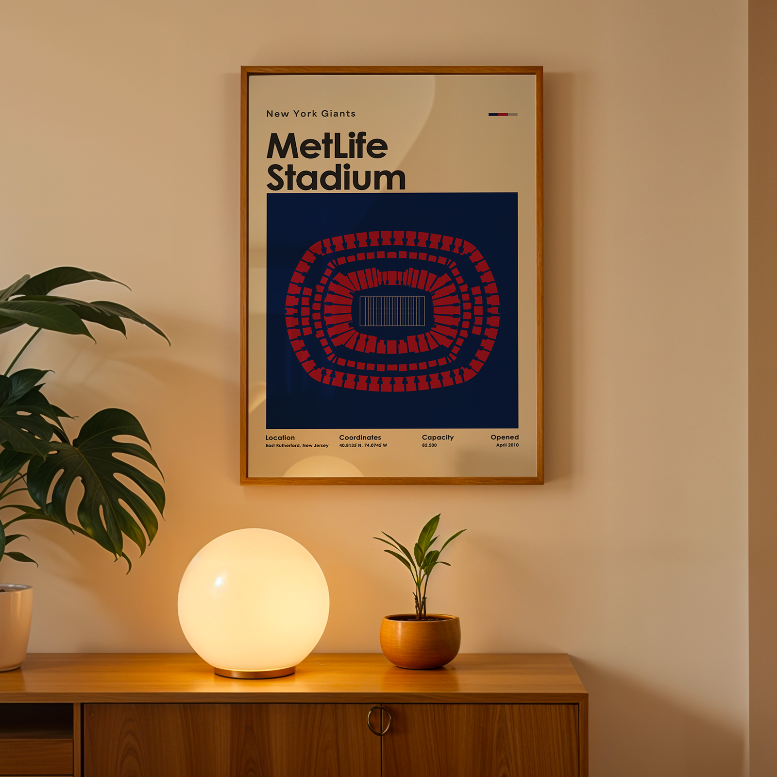 Framed poster of MetLife Stadium on a wall above a wooden cabinet with decorative items.