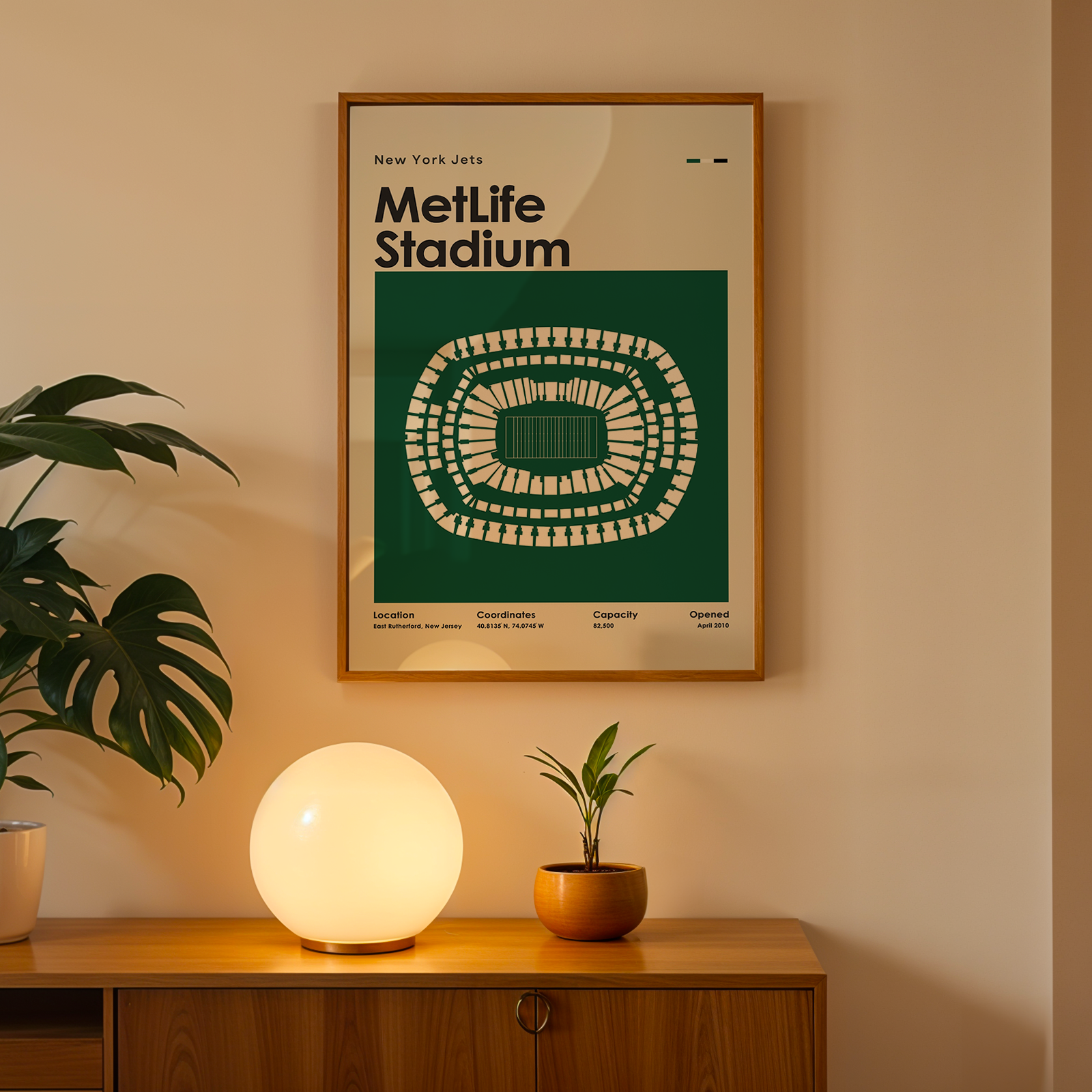 Framed poster of MetLife Stadium on a wall above a wooden cabinet with decorative items.