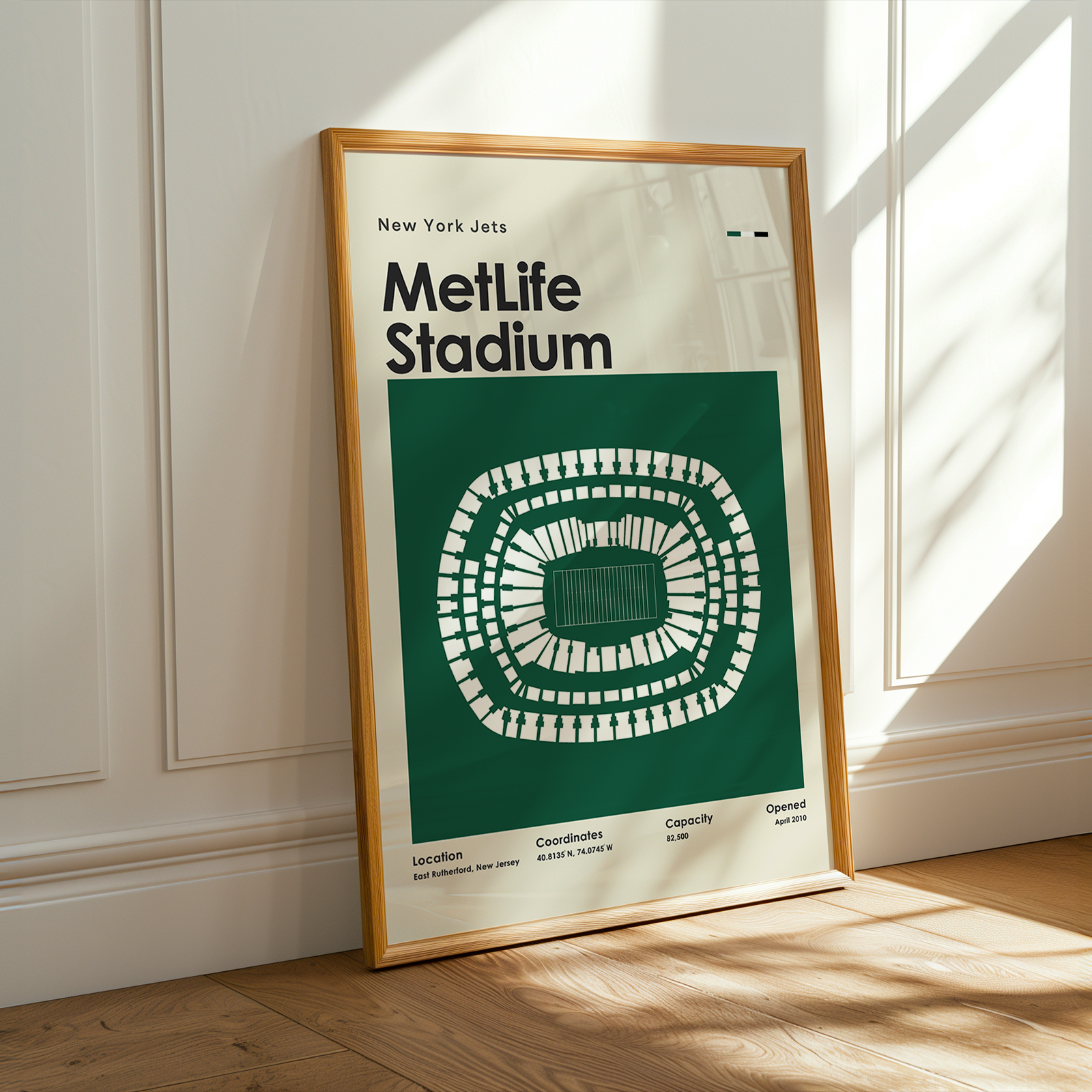 Framed poster of MetLife Stadium layout on a wooden floor with sunlight streaming through a window.
