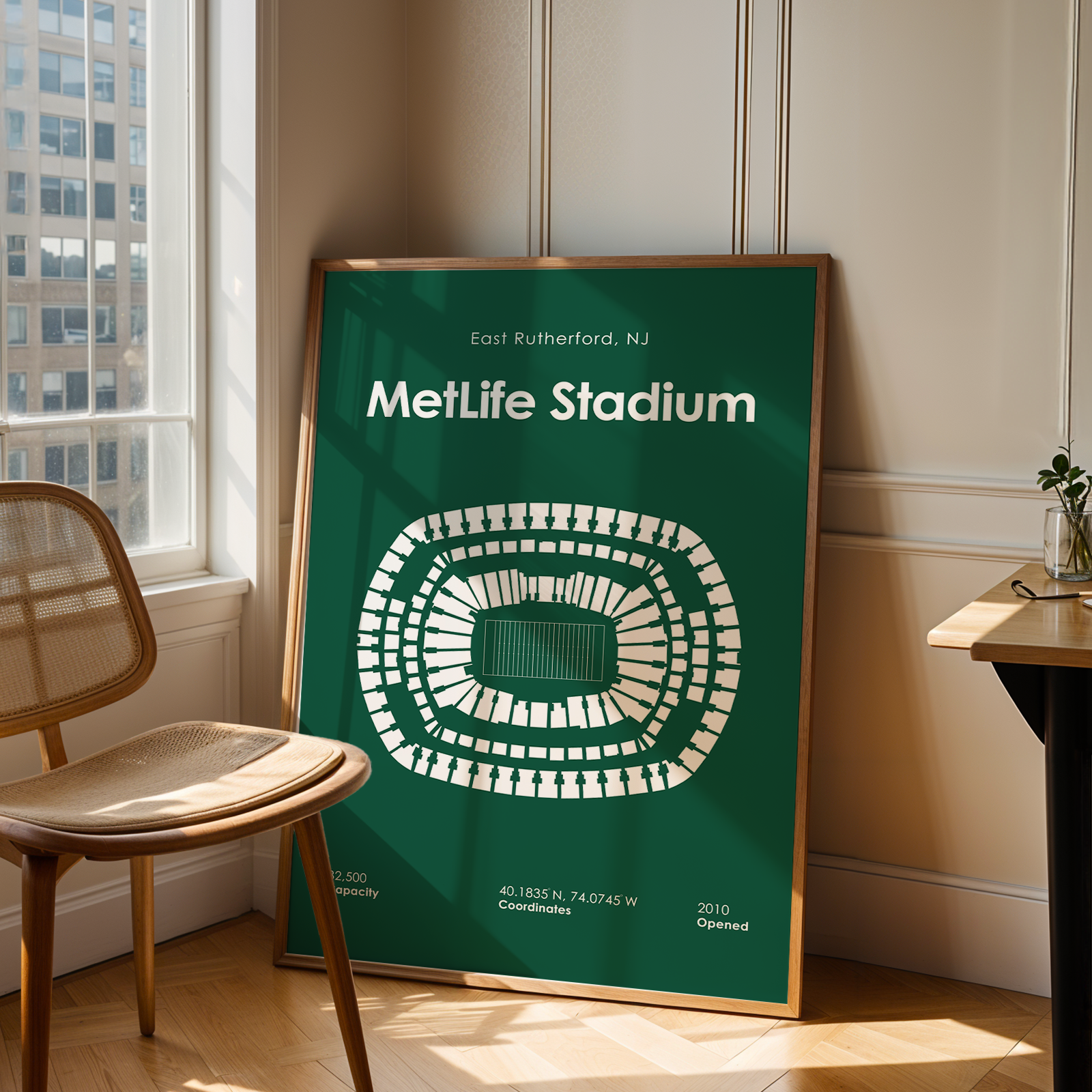 Framed poster of MetLife Stadium in a room with a chair and table.