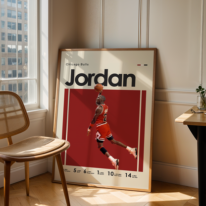 Framed poster of a basketball player named 'Jordan' leaning against a wall in a room with a chair and table.