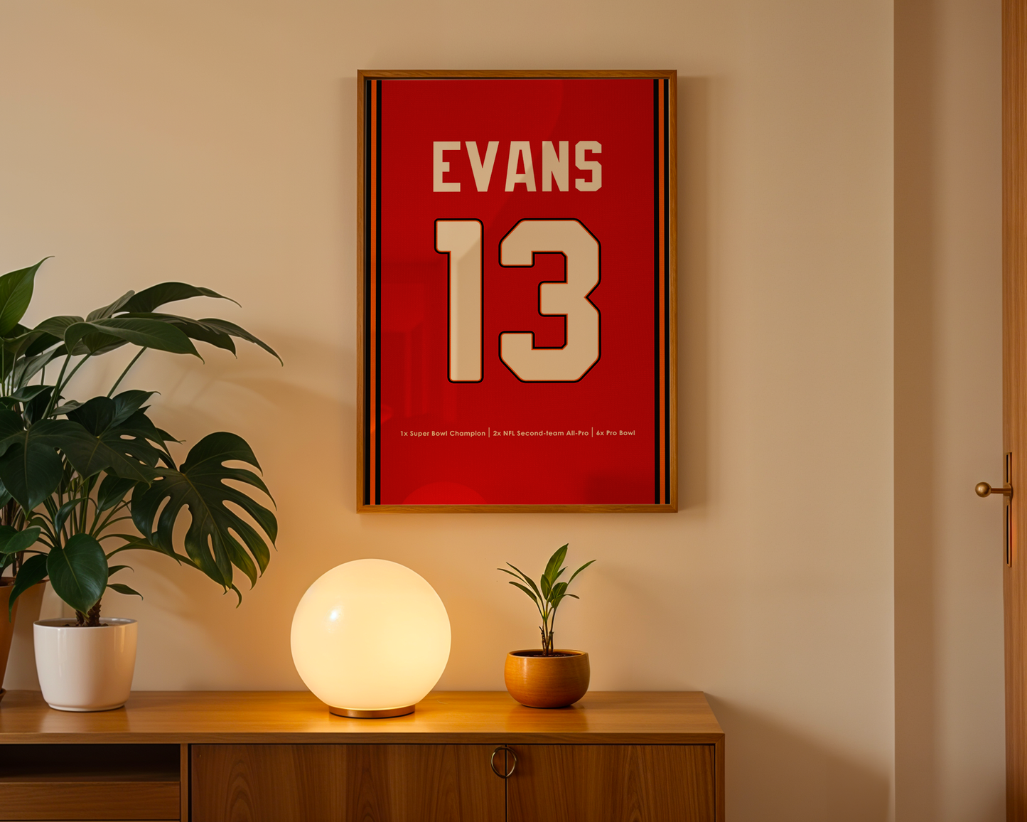 Red framed poster with 'EVANS 13' on a wall above a wooden cabinet with decorative items.