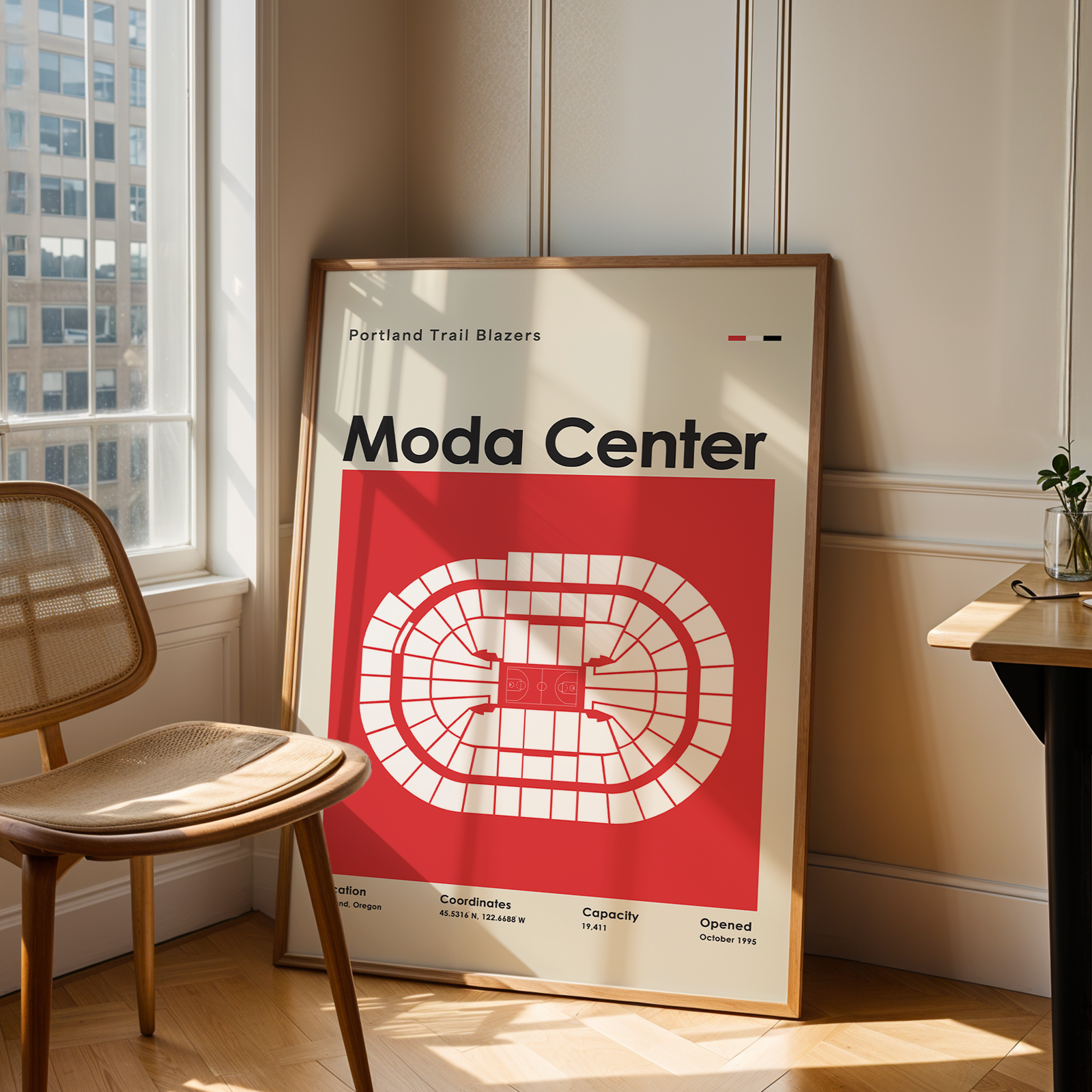 Poster of Moda Center in a room with a chair and table.