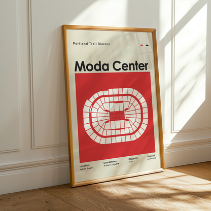 Framed poster of Moda Center with a red and white design on a wooden floor.