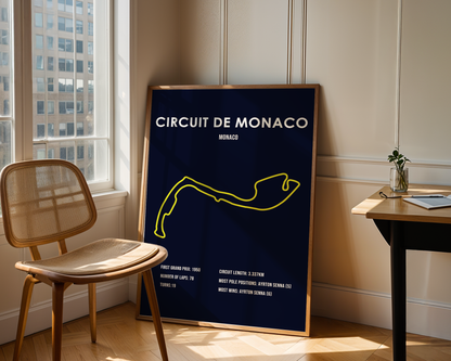 Framed poster of Circuit de Monaco in a room with a chair and table.