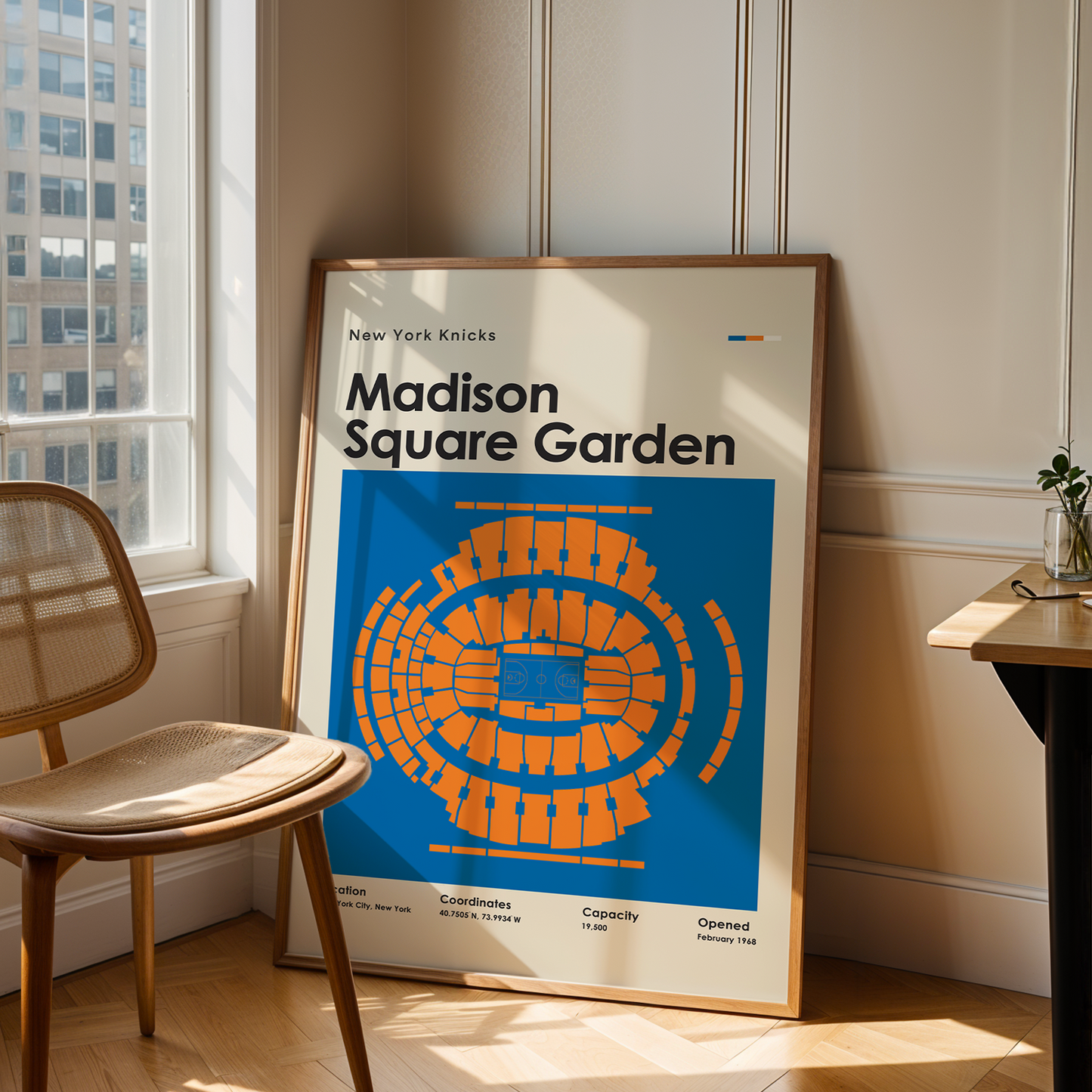 Framed poster of Madison Square Garden in a room with a chair and table.
