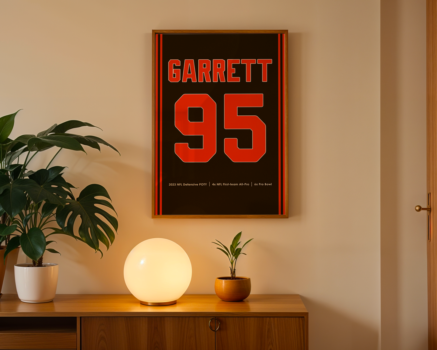 Framed poster with 'Garrett 95' on a wall above a wooden cabinet with decorative items.