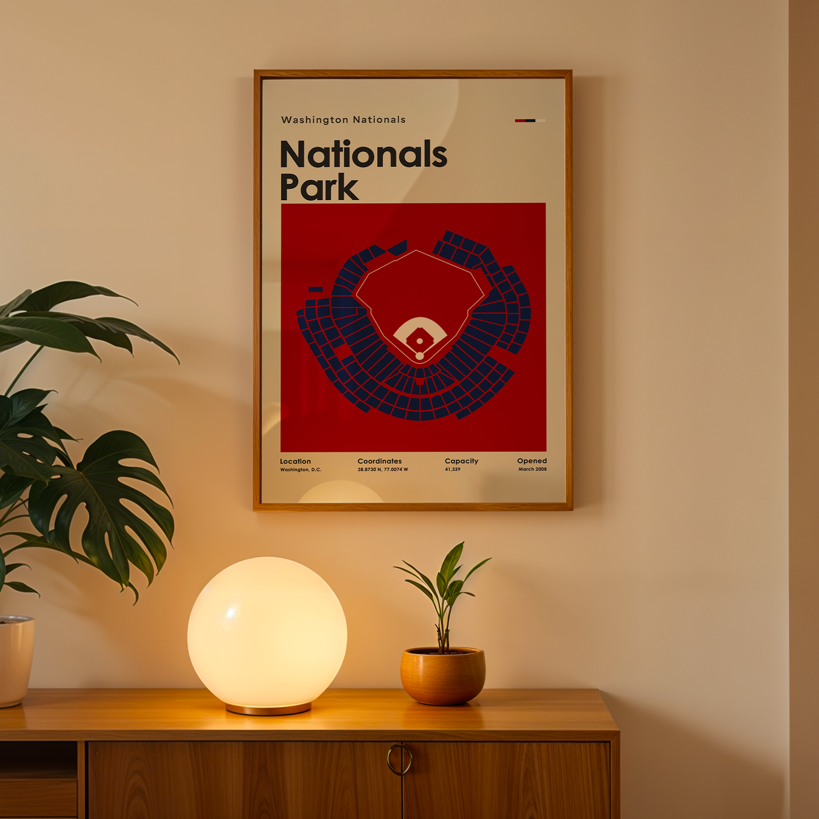 Framed poster of Nationals Park on a wall above a wooden cabinet with decorative items.