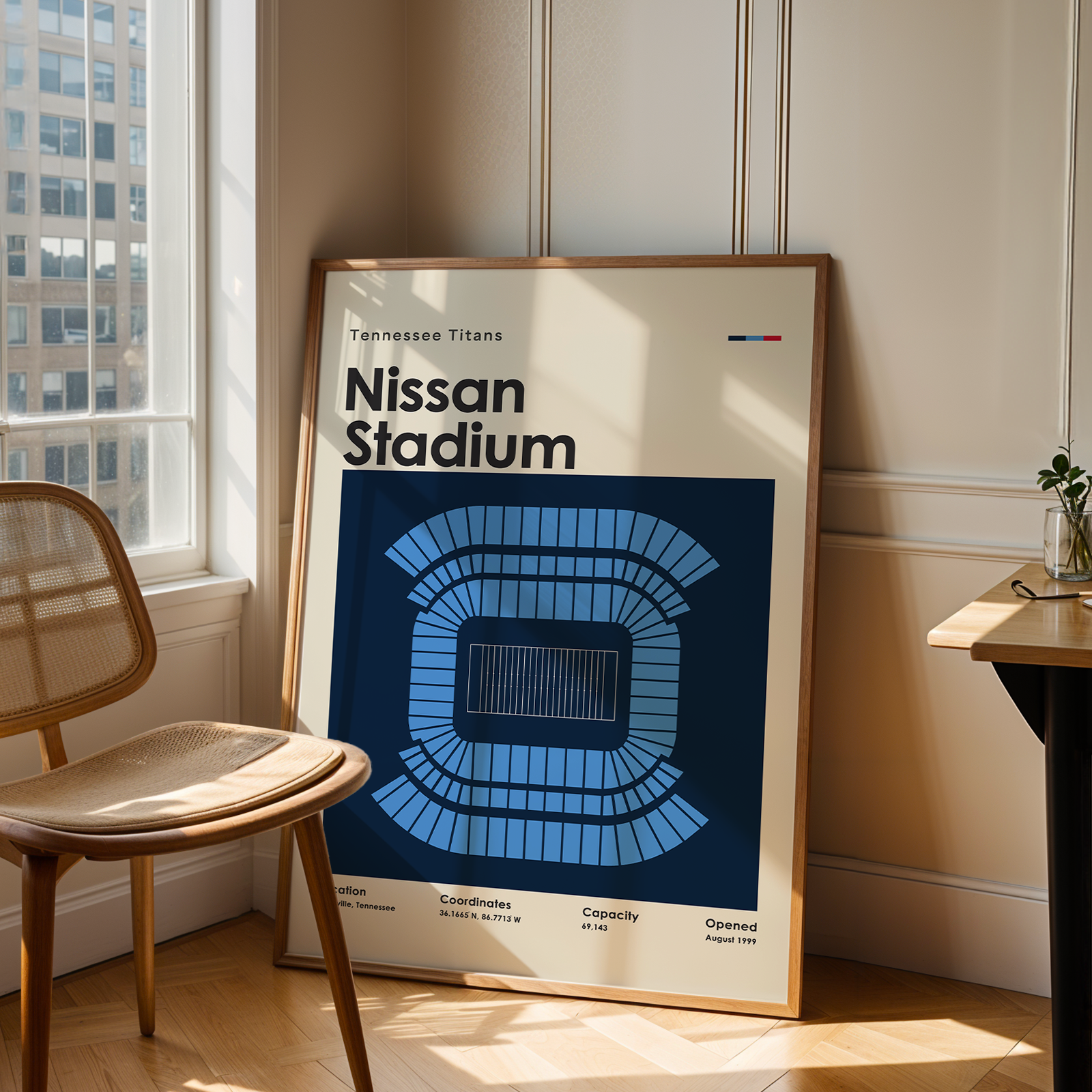 Framed poster of Nissan Stadium in a room with a window and chair.