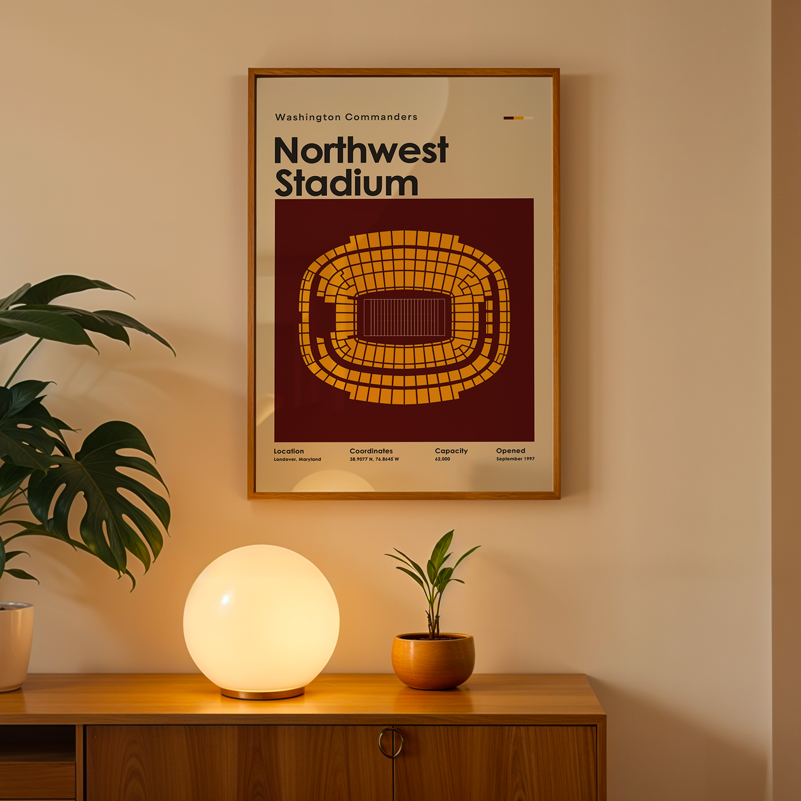 Framed poster of Northwest Stadium on a wall above a wooden cabinet with decorative items.
