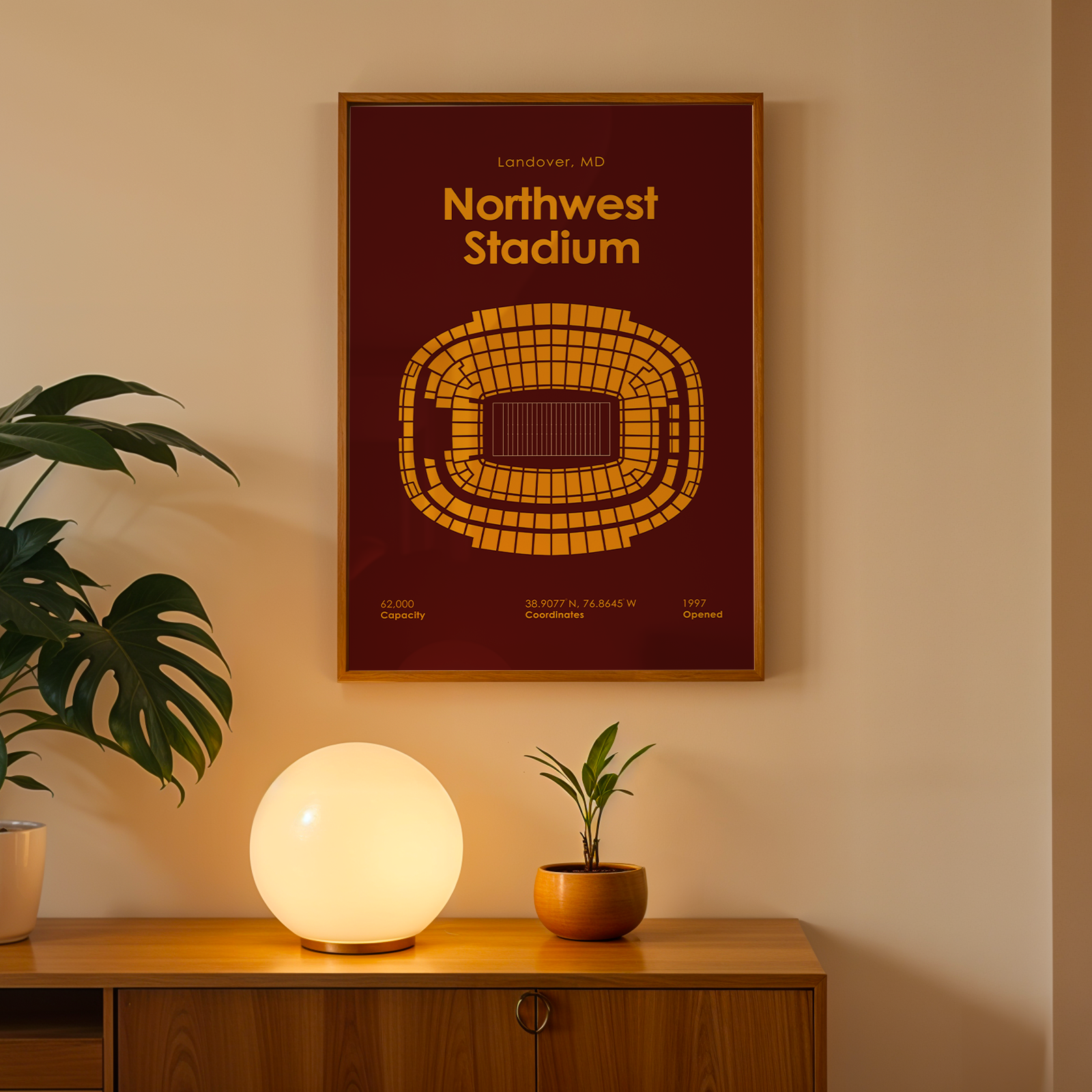 Framed poster of Northwest Stadium on a wall above a wooden cabinet with decorative items.
