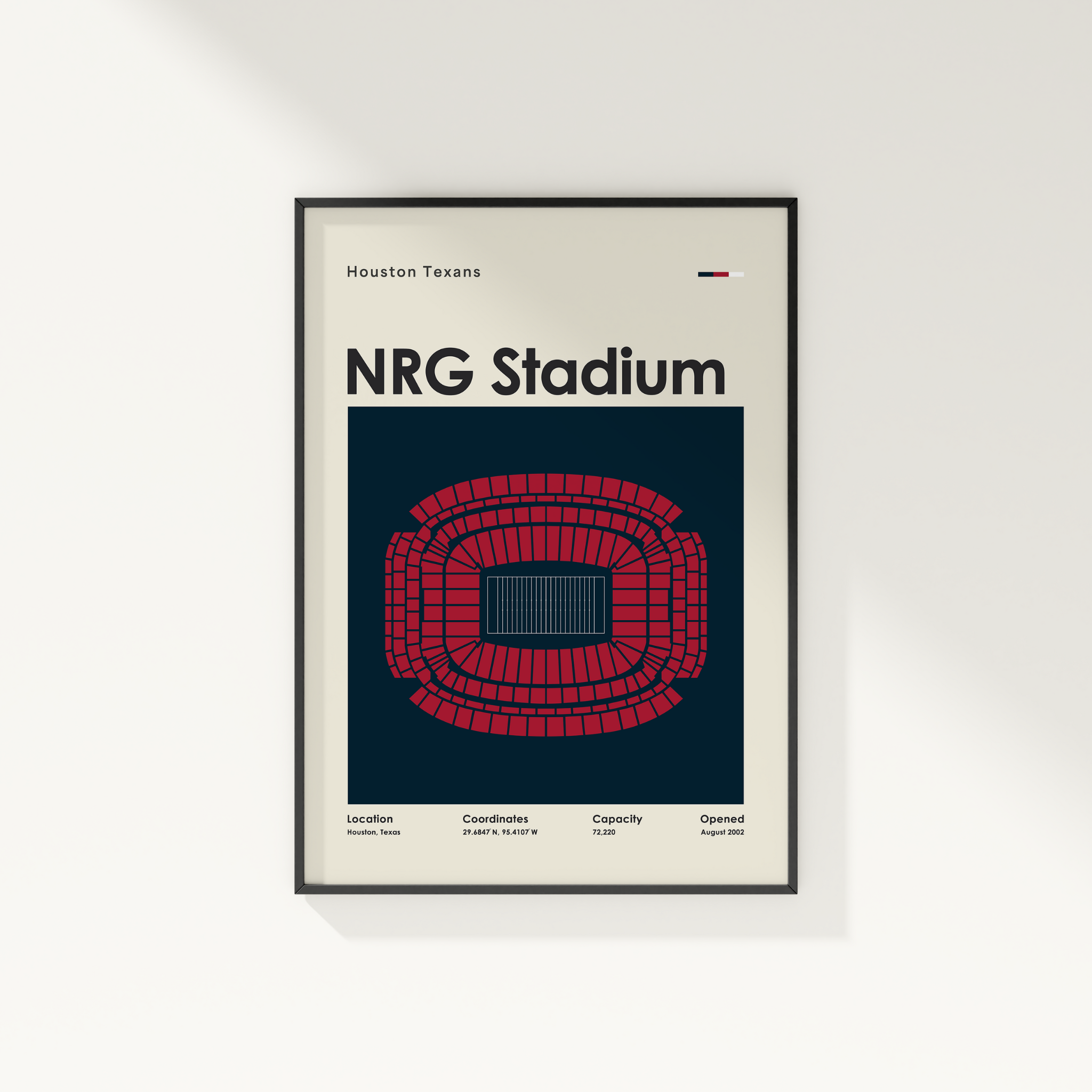 Framed poster of NRG Stadium with Houston Texans branding on a white wall.