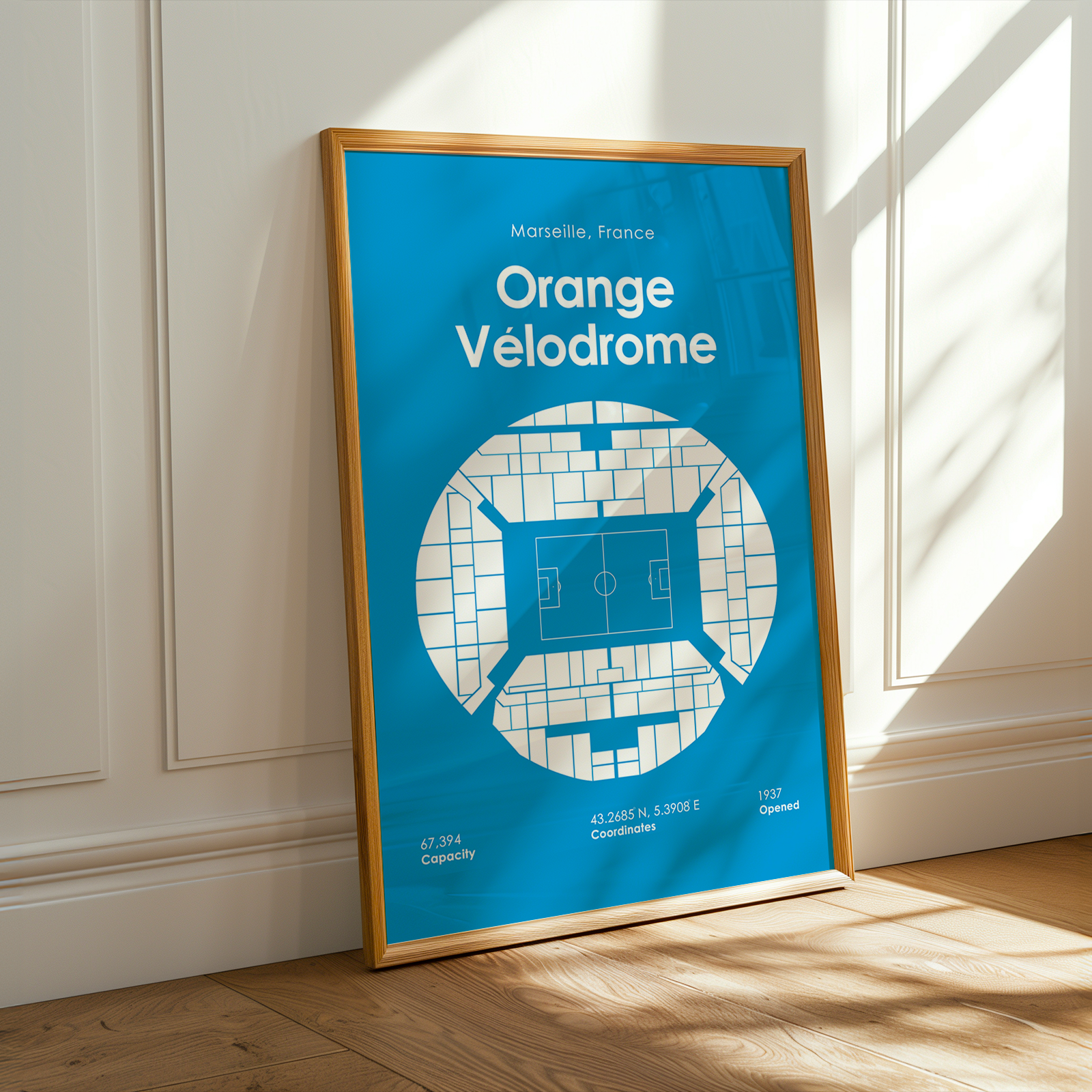 Framed poster of Orange Velodrome in Marseille, France on a wall.