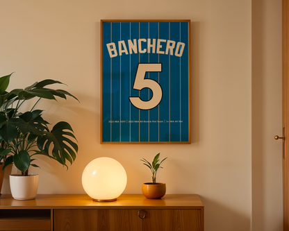 Framed sports jersey with 'Banchero' and number '5' on a wall above a wooden cabinet with decorative items.