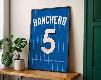 Framed sports jersey with 'Banchero' and number '5' on a wooden shelf.
