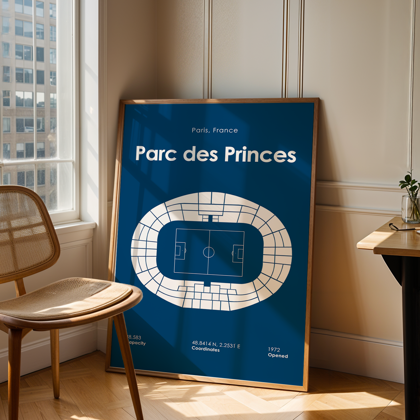 Poster of Parc des Princes in a room with a chair and window.