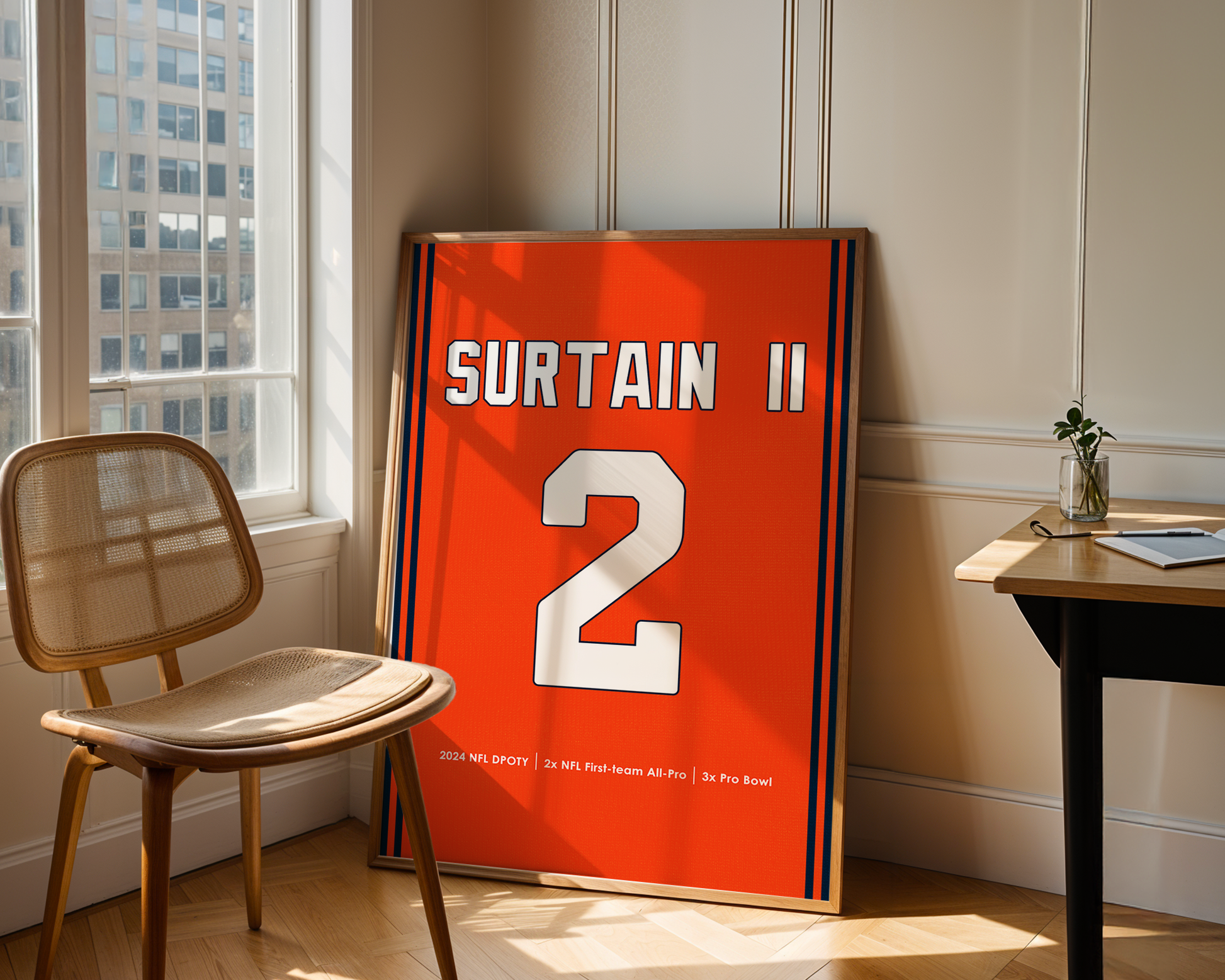 Framed sports jersey with 'Surtain II' and number '2' in a room with a window and chair.