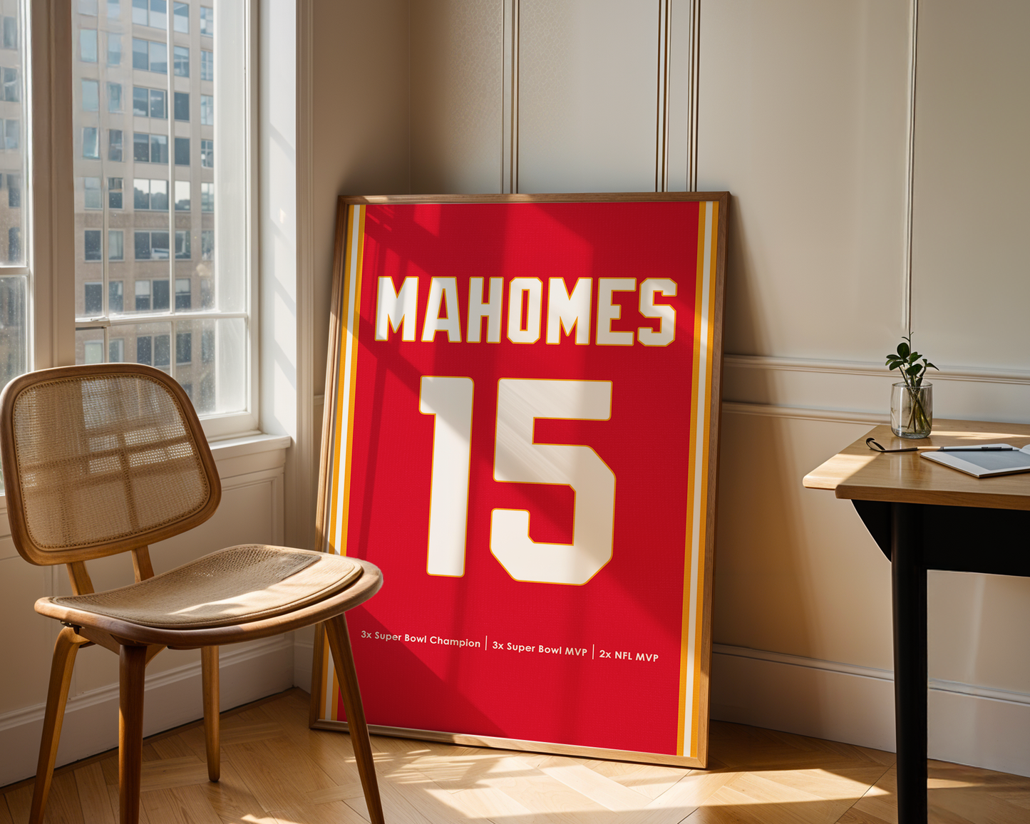 Framed sports jersey with 'Mahomes 15' on a wall in a room with a chair and table.