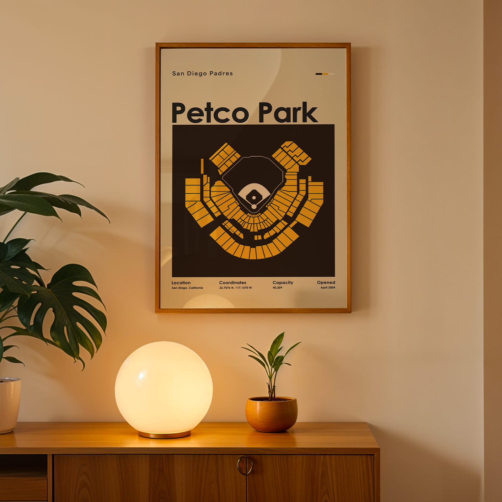 Framed 'Petco Park' poster on a wall above a wooden cabinet with decorative items.