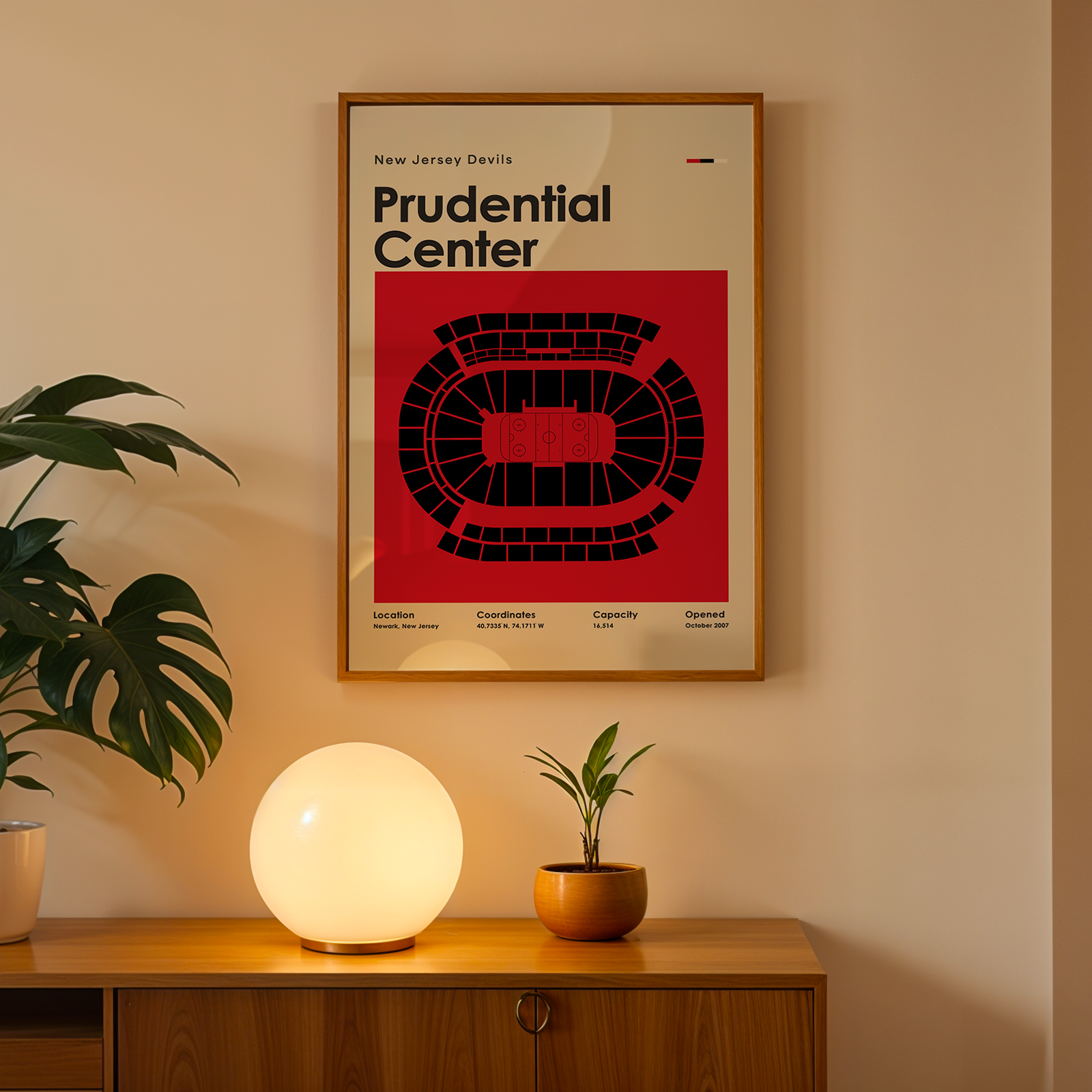 Framed poster of Prudential Center on a wall above a wooden cabinet with decorative items.