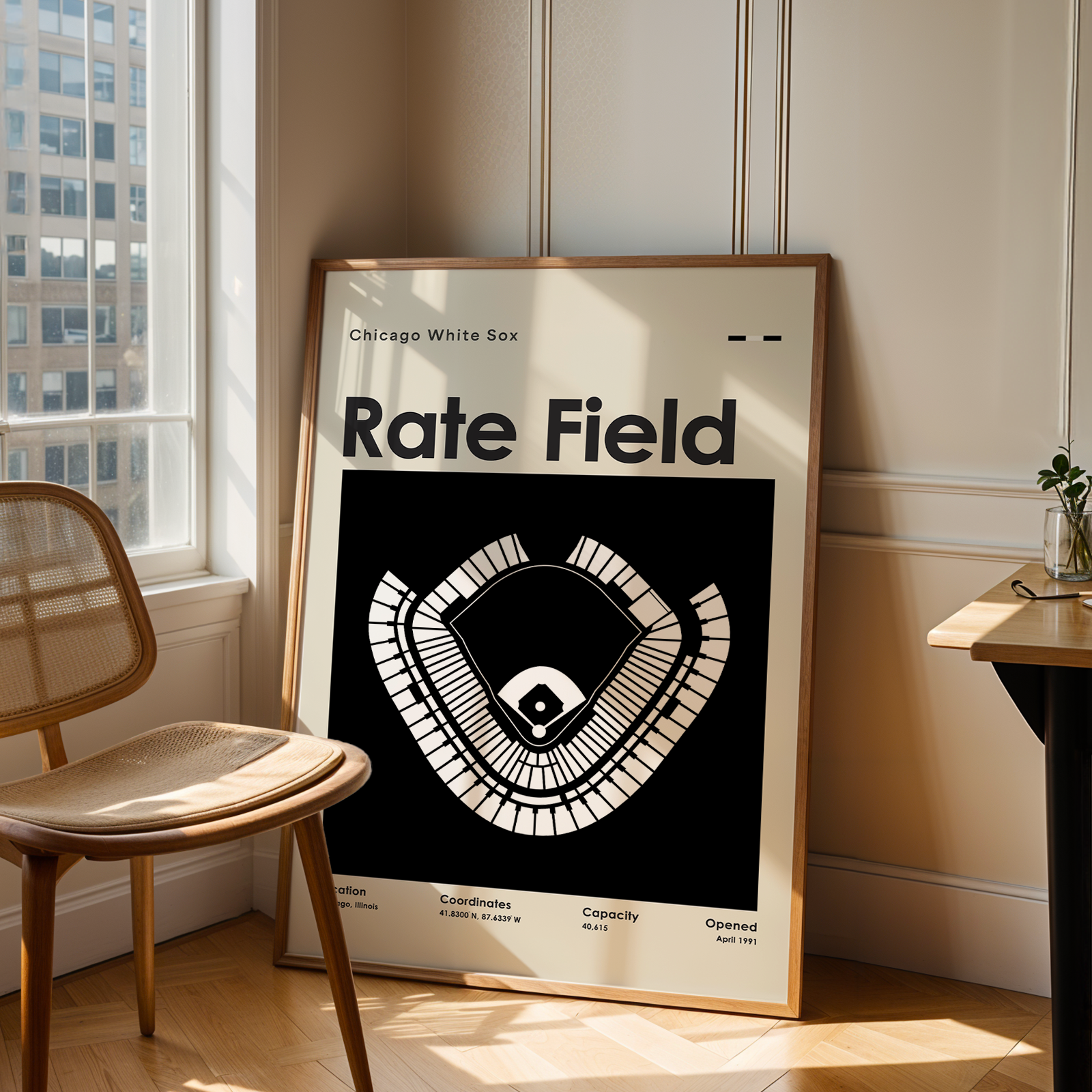 Framed poster of a baseball stadium layout titled 'Rate Field' in a room with a chair and table.