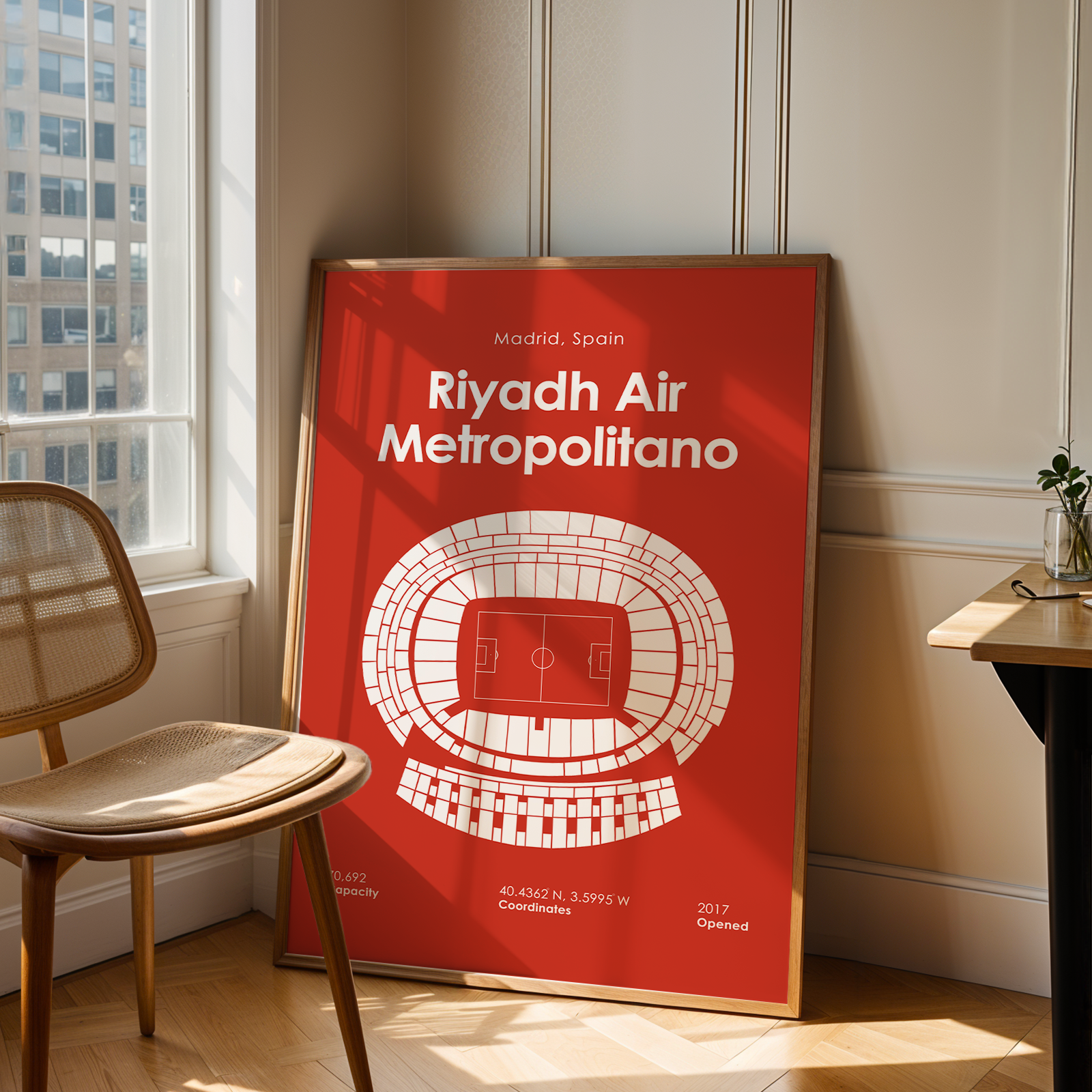 Poster of Riyadh Air Metropolitano stadium in a room with a chair and window.