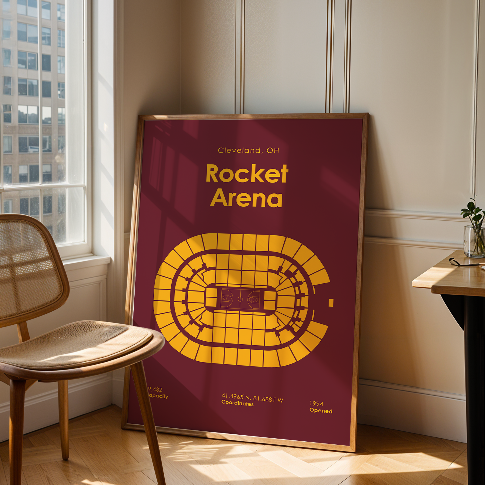 Poster of Rocket Arena in Cleveland, OH, leaning against a wall in a room with a chair and table.