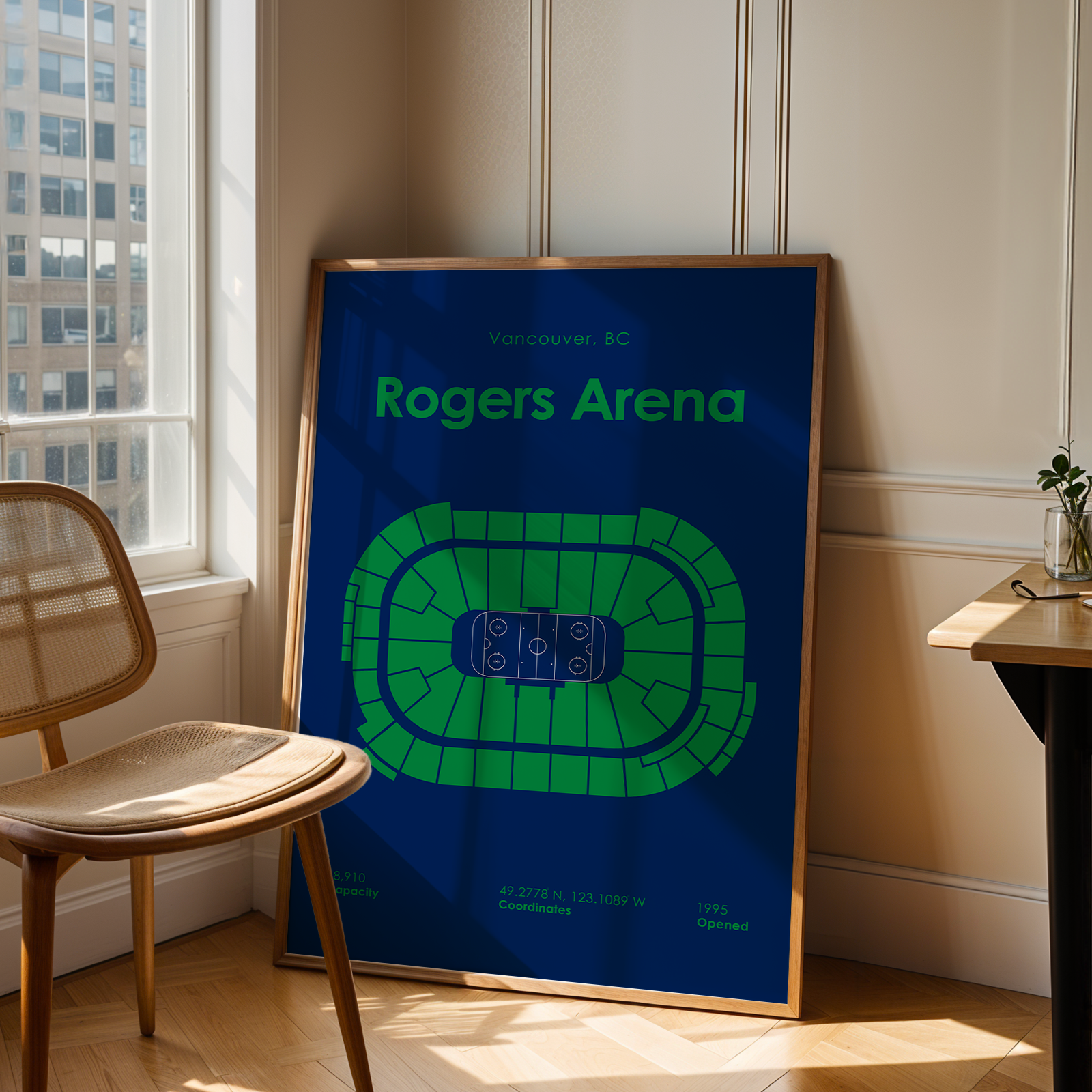 Framed poster of Rogers Arena in a room with a window and chair.