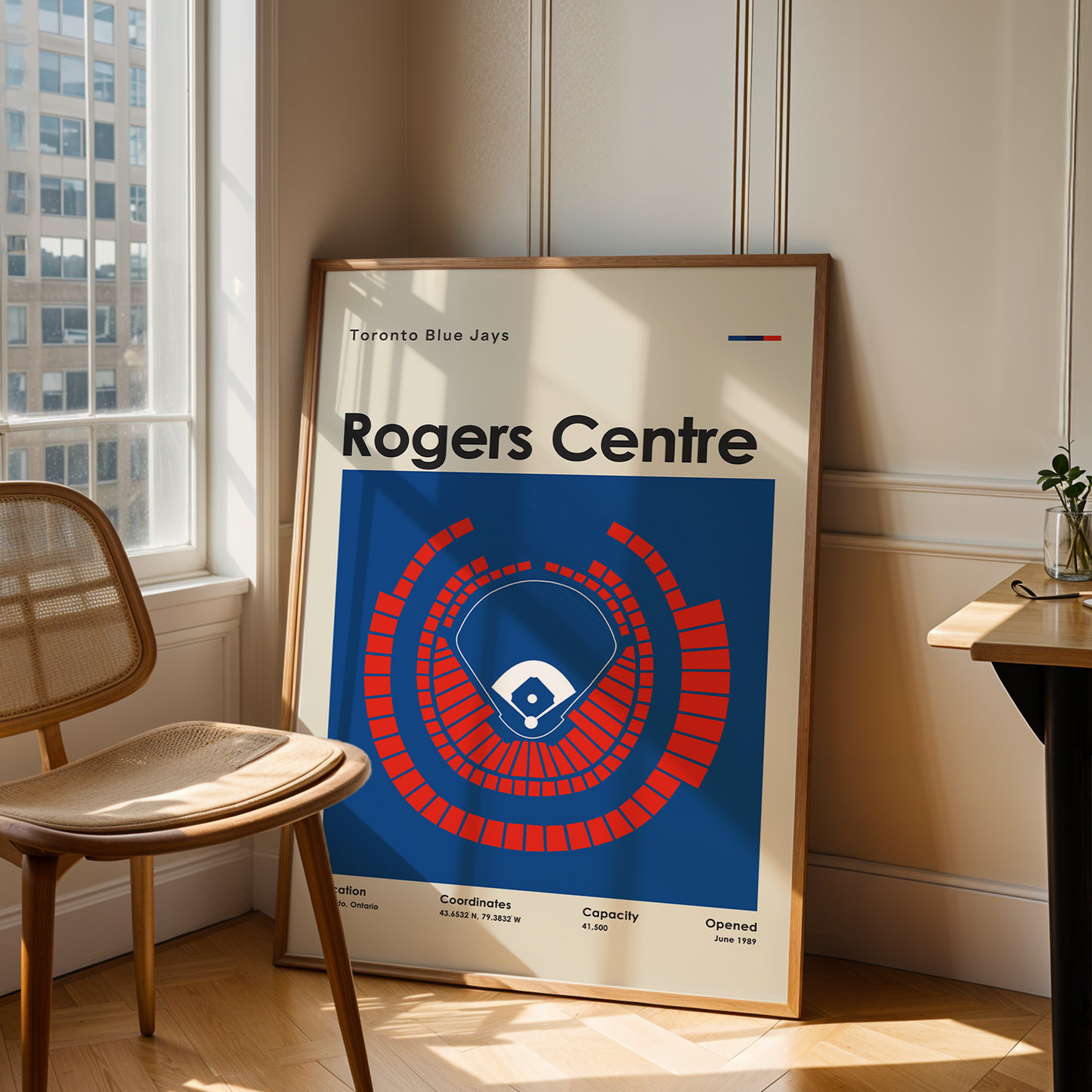Framed poster of Rogers Centre in a room with a chair and table.