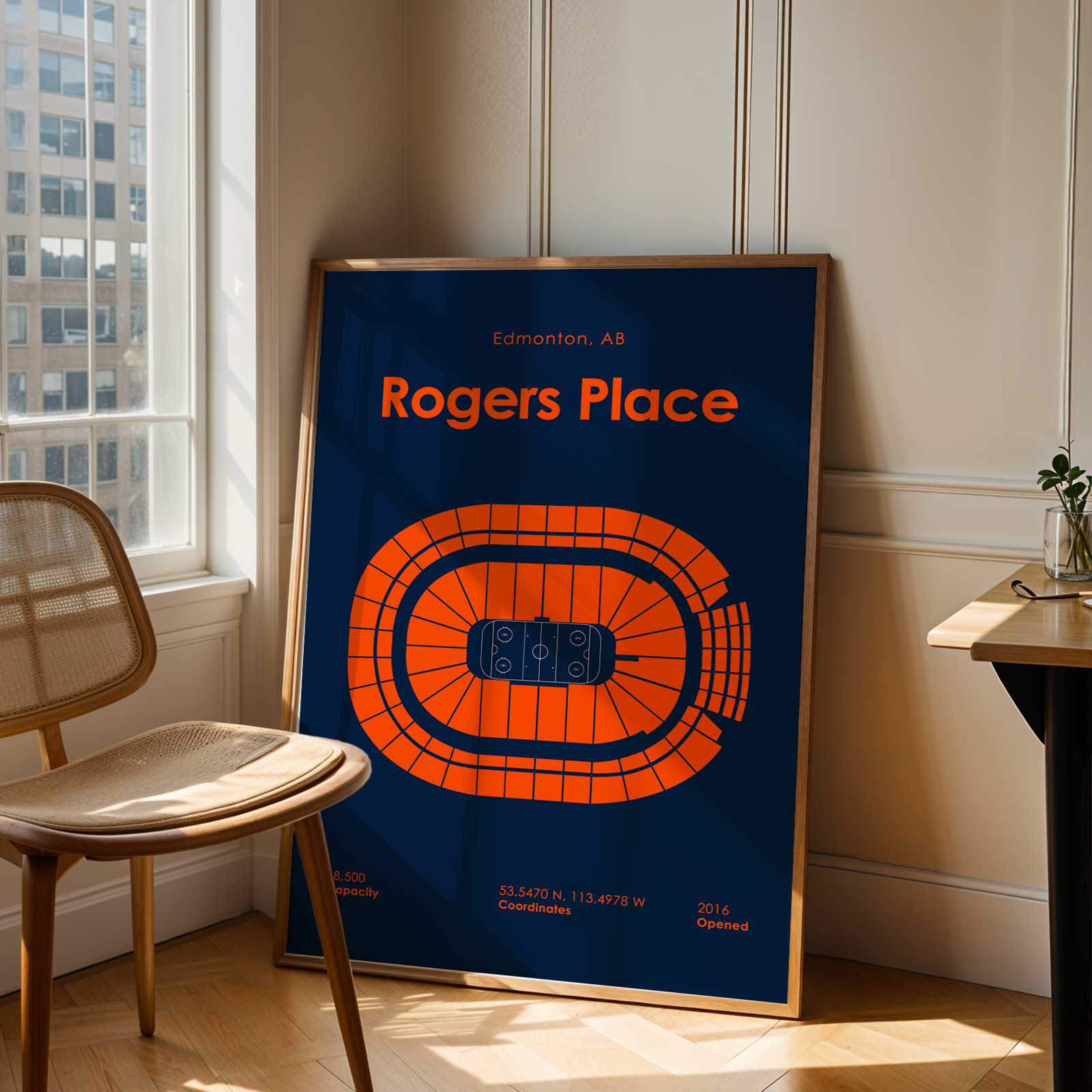 Framed poster of Rogers Place in Edmonton, displayed in a room with a window and chair.