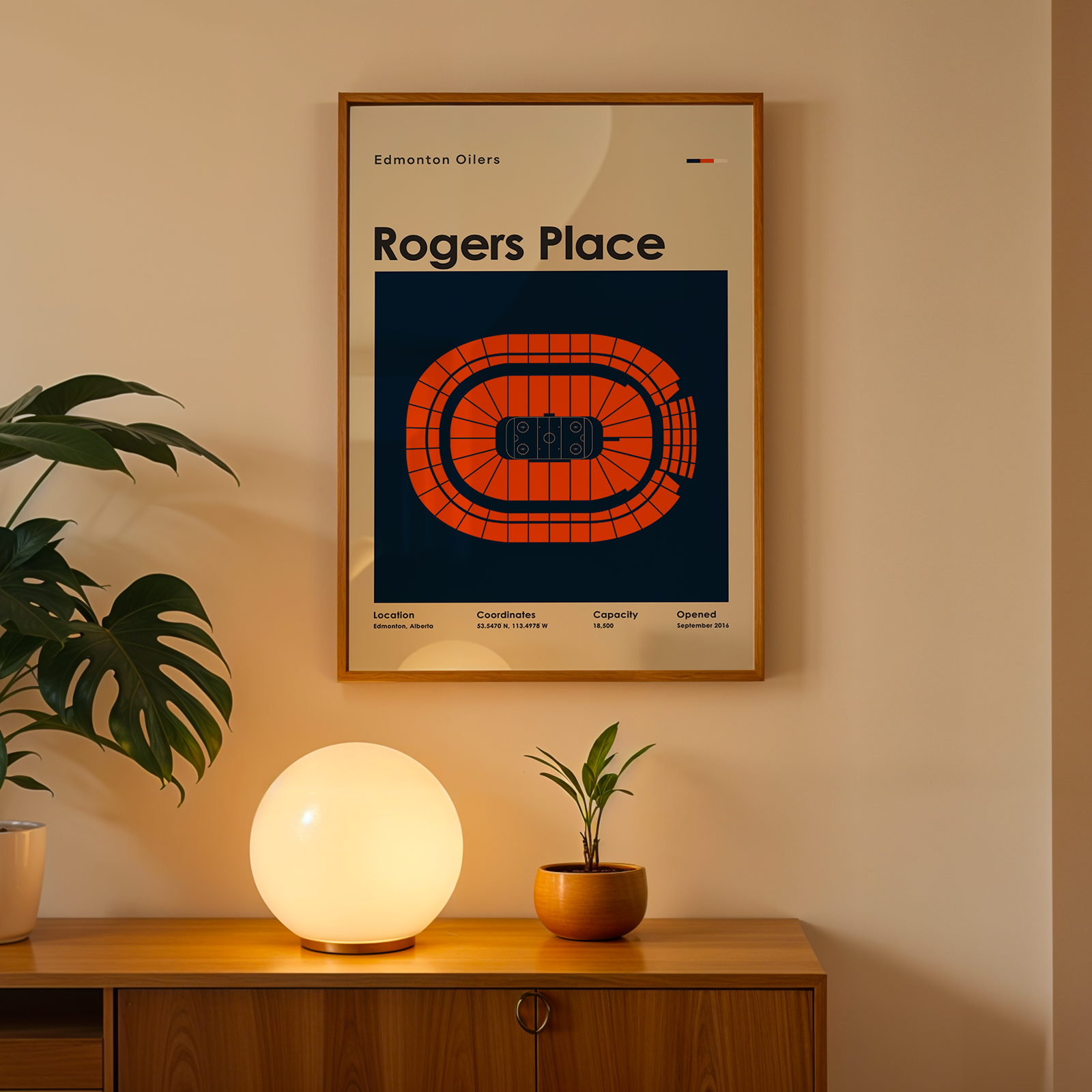 Framed poster of Rogers Place on a wall above a wooden cabinet with decorative items.