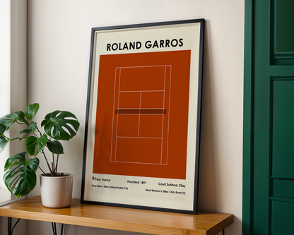 Framed poster of Roland Garros tennis court design on a wall with a plant and wooden shelf.