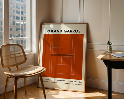 Framed poster of Roland Garros tennis court design in a room with a chair and table.