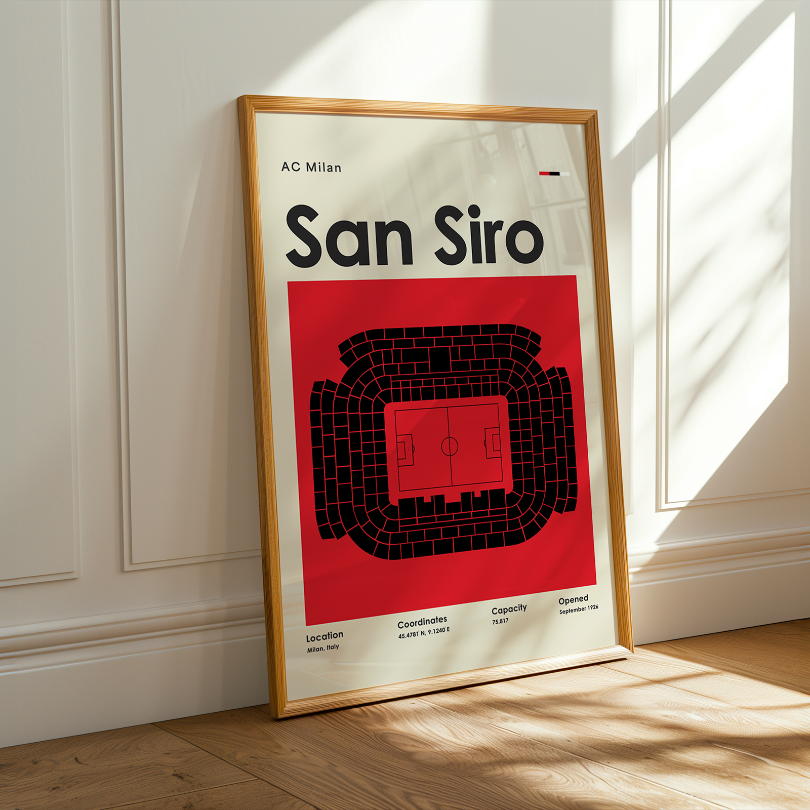 Framed poster of San Siro stadium layout with AC Milan branding on a white wall.