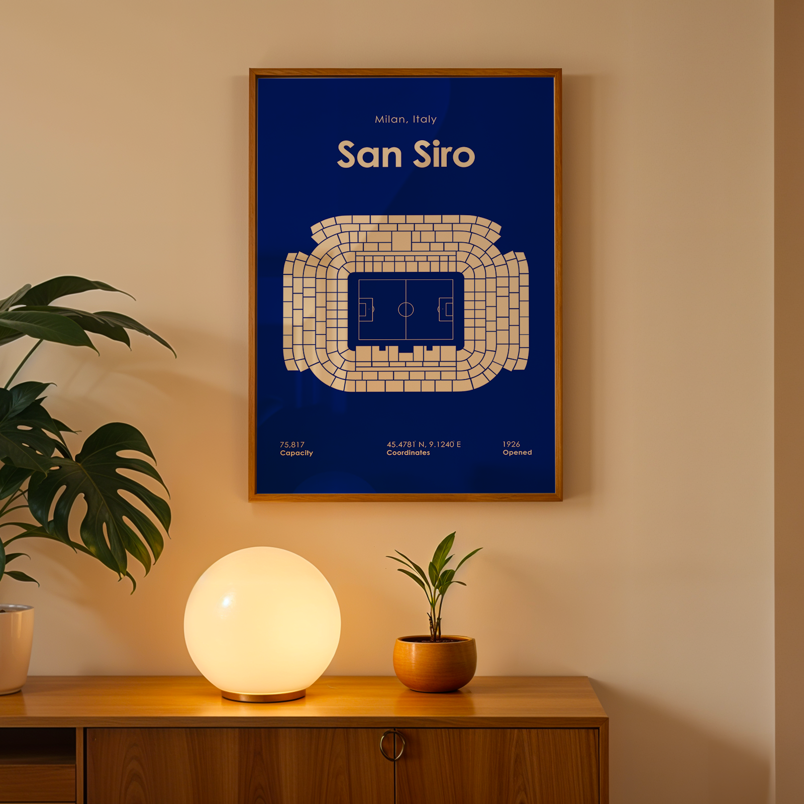 Framed poster of San Siro stadium layout on a wall with decorative elements below.