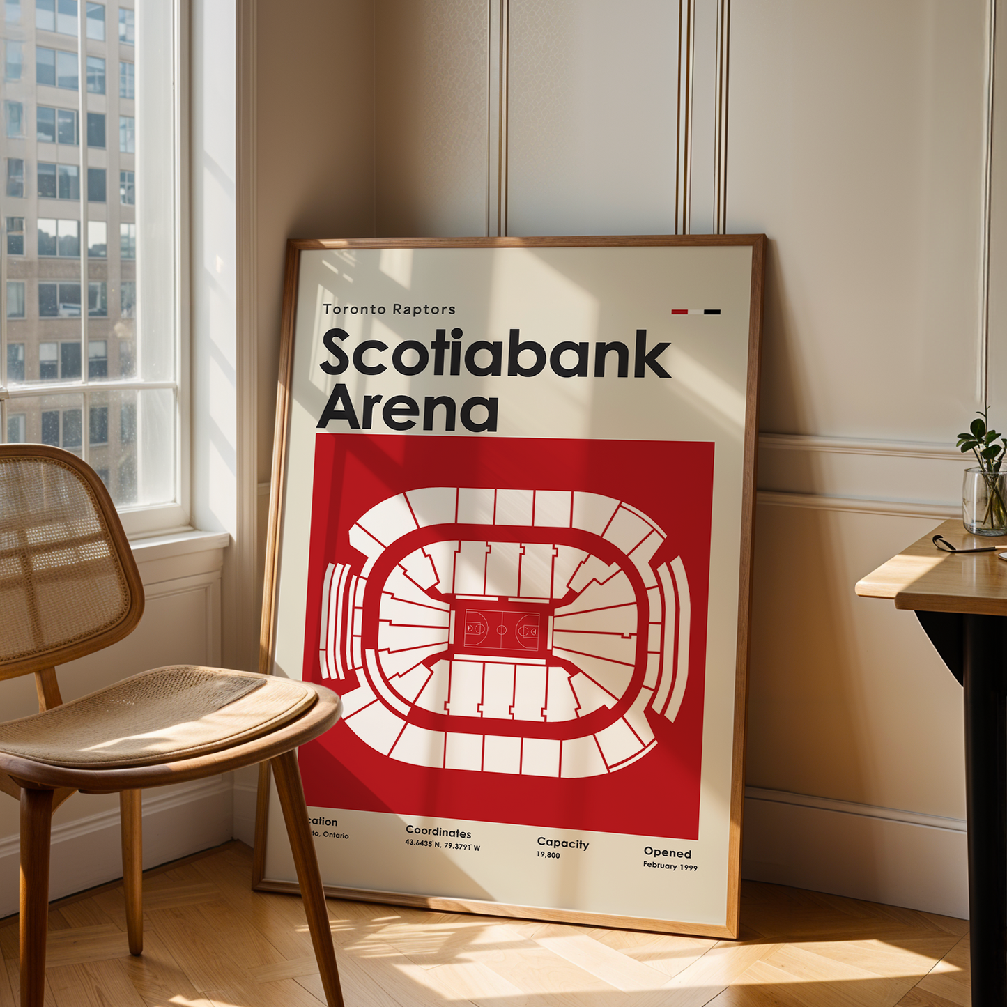 Framed poster of Scotiabank Arena in a room with a chair and table.
