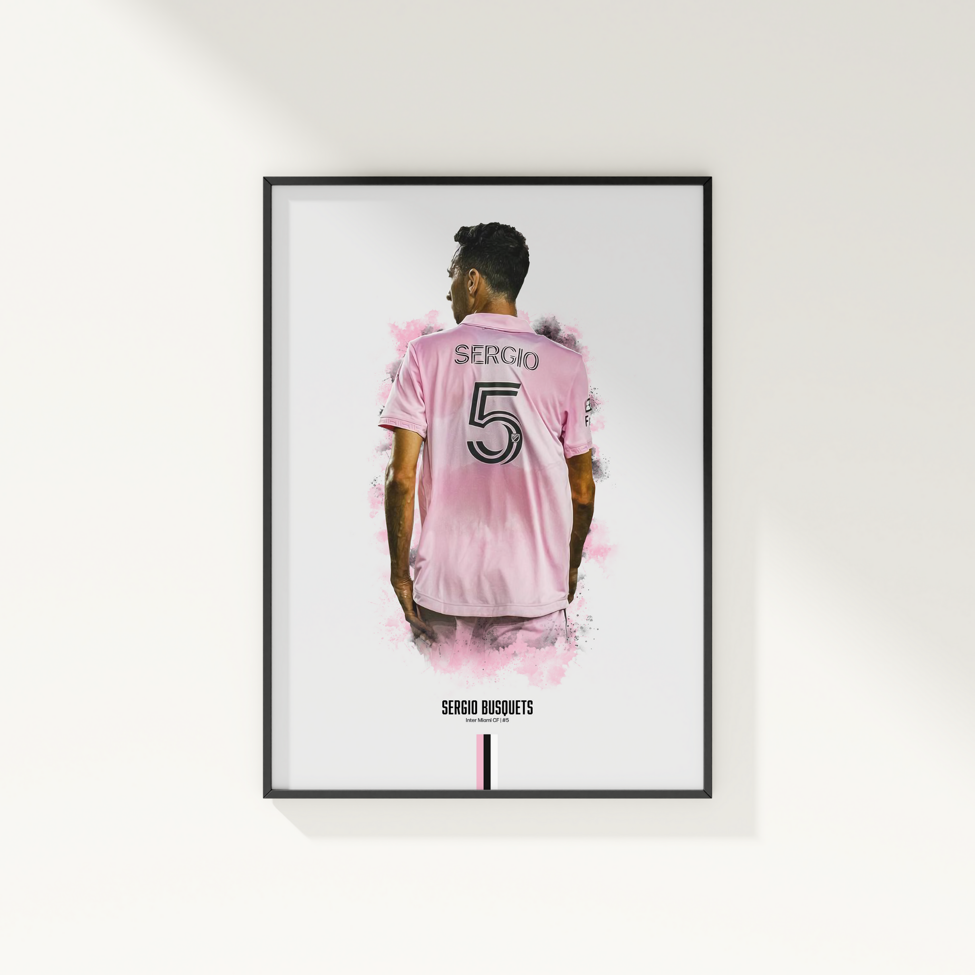 framed poster mockup of soccer player sergio busquets hanging on a white wall