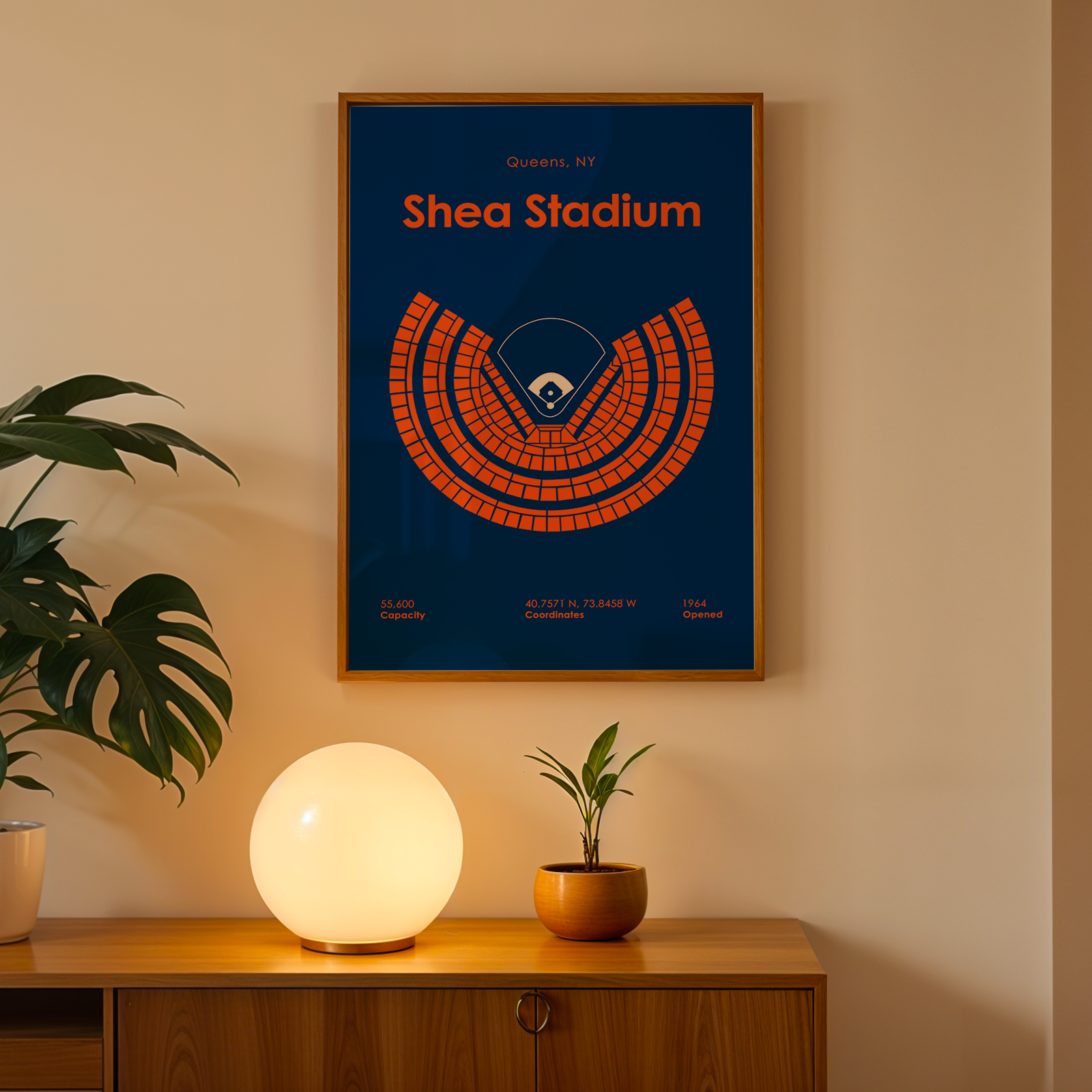 Framed 'Shea Stadium' poster on a wall above a wooden cabinet with decorative items.