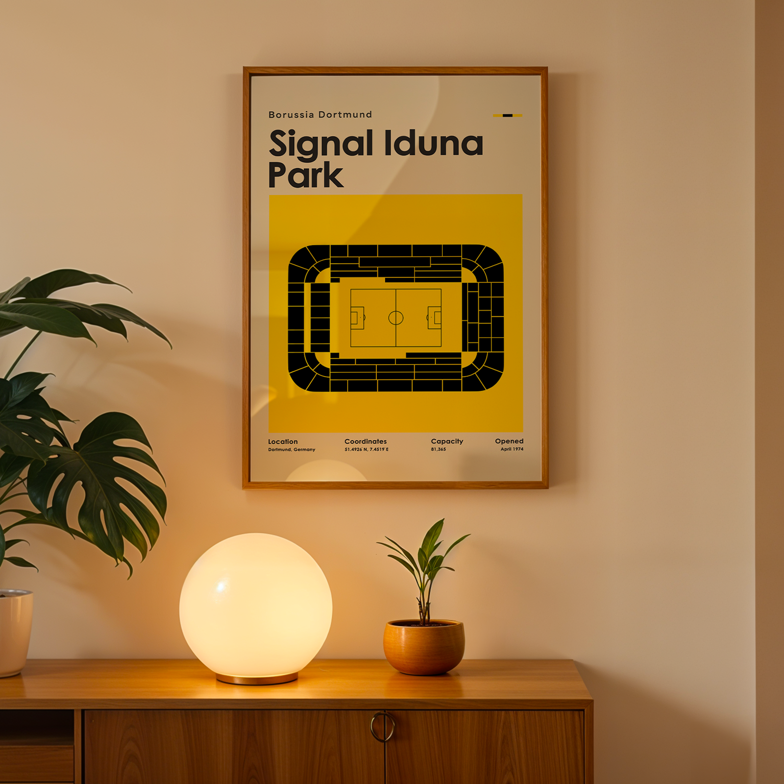 Framed poster of Signal Iduna Park on a wall above a wooden cabinet with decorative items.