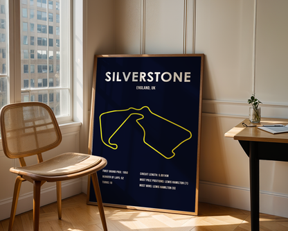 Poster of Silverstone circuit in a room with a chair and table.
