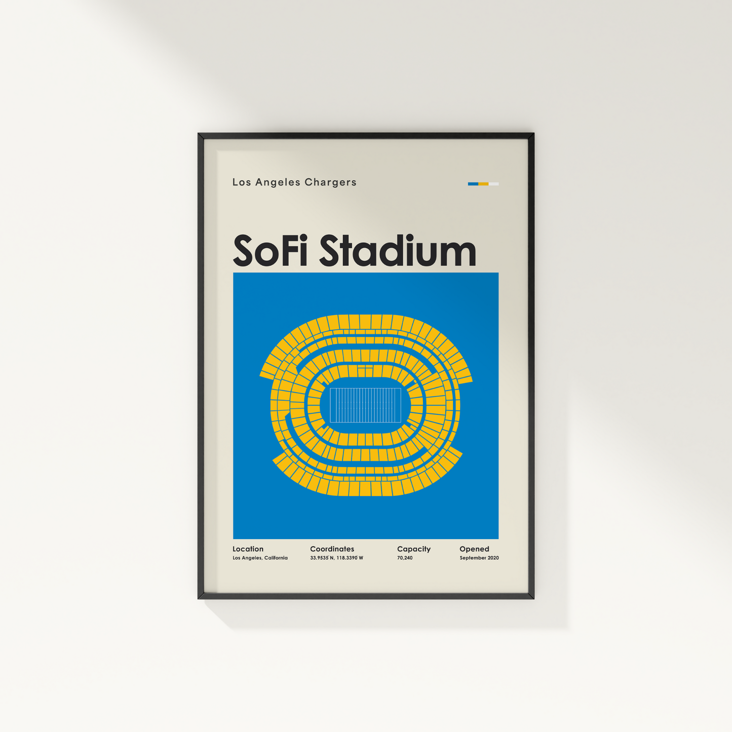 Framed poster of SoFi Stadium with blue and yellow design on a white wall.