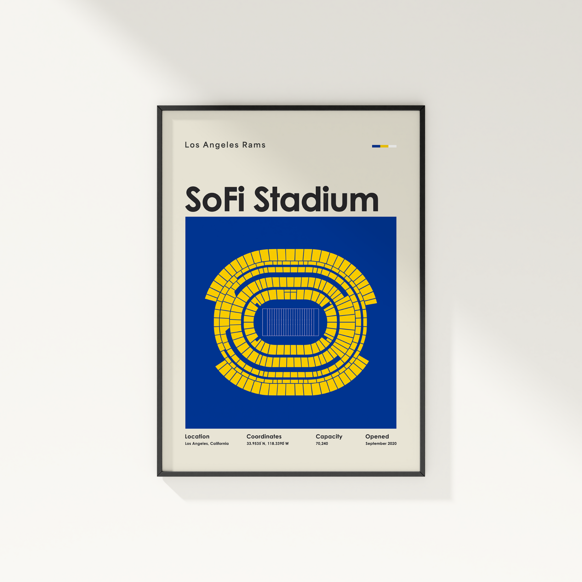 Framed poster of SoFi Stadium with seating chart and text on a white wall.