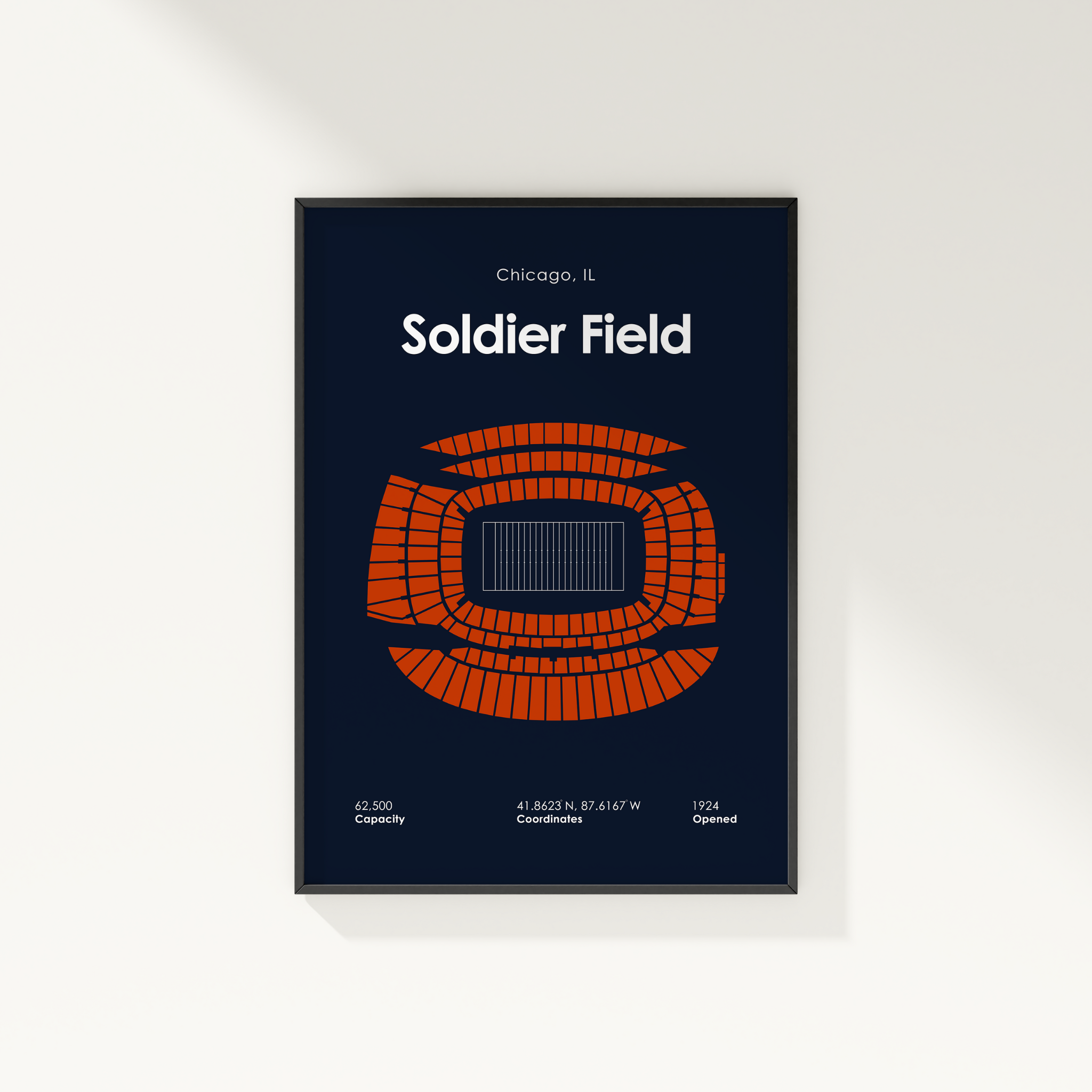 Framed poster of Soldier Field with orange seating pattern on a dark blue background.