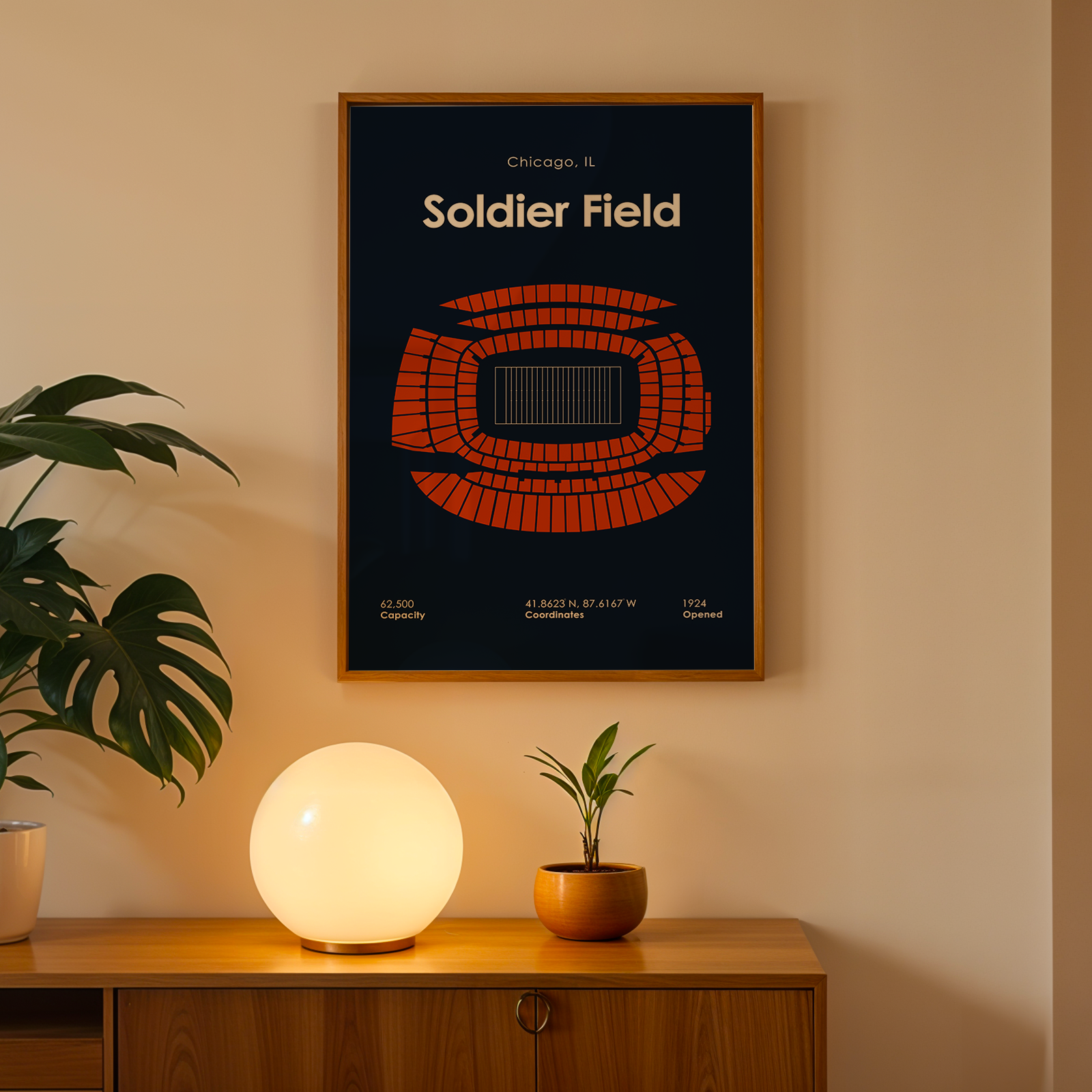 Framed poster of Soldier Field on a wall above a wooden cabinet with decorative items.