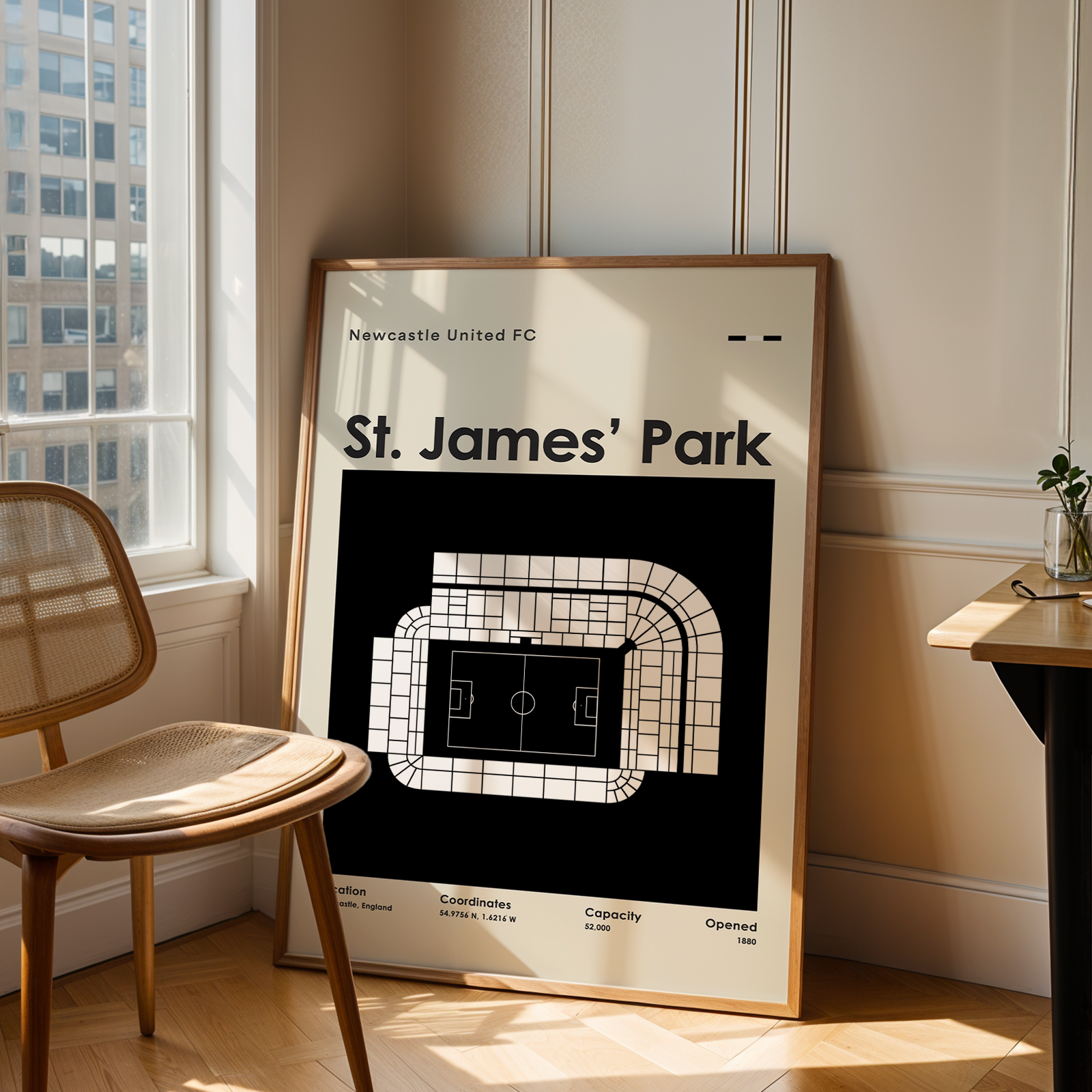 Framed poster of St. James' Park in a room with a chair and table.
