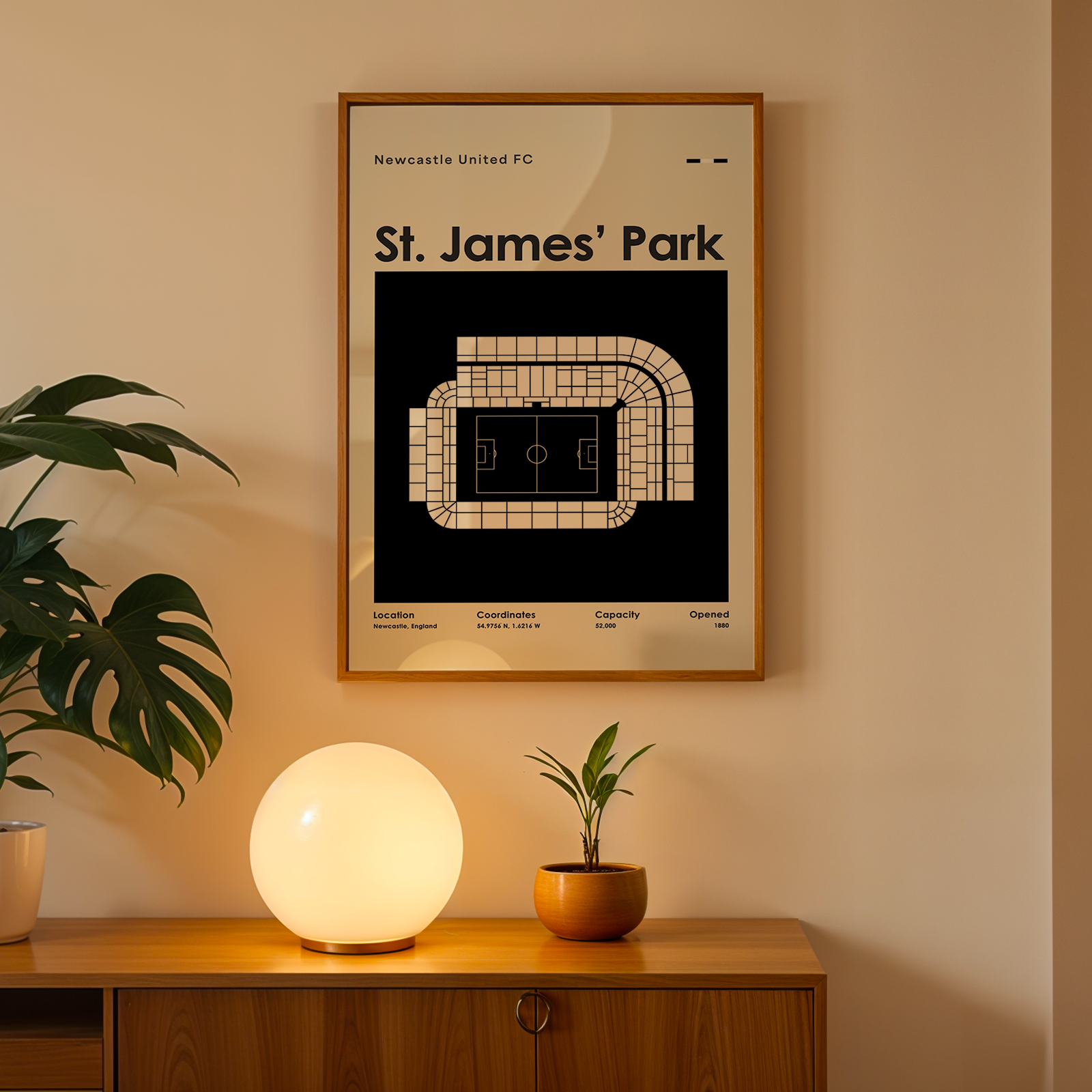 Framed poster of St. James' Park on a wall above a wooden cabinet with decorative items.