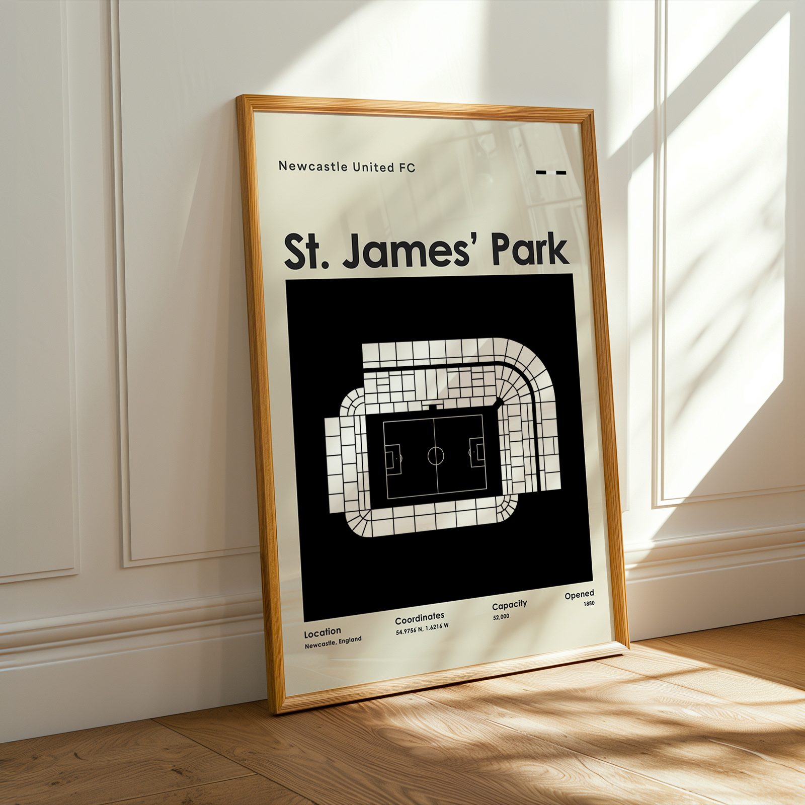 Framed poster of St. James' Park stadium layout on a wall.