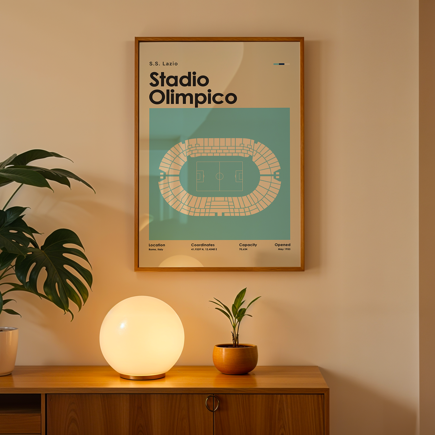 Framed poster of Stadio Olimpico on a wall above a wooden cabinet with decorative items.