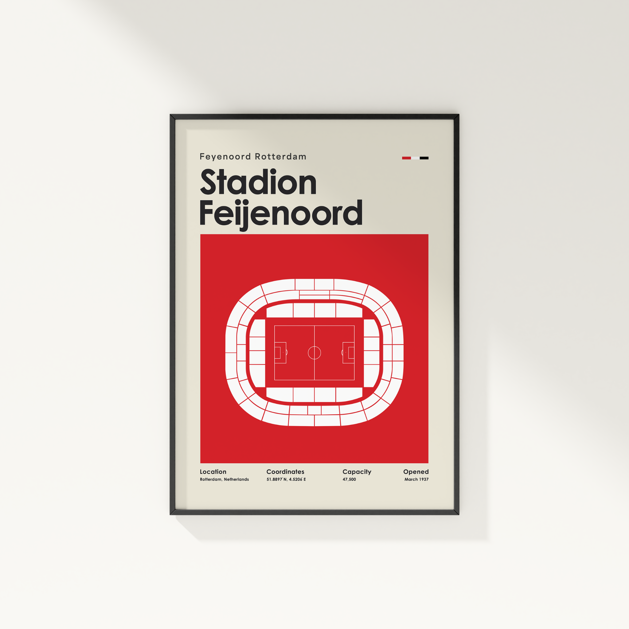 A framed minimalist poster of Feyenoord Rotterdam Stadion Feijenoord, featuring a red background with a white stadium outline and black text, displayed on a light gray wall.